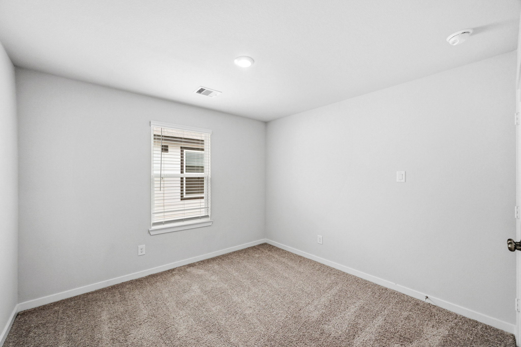 A room with a window and a carpet.