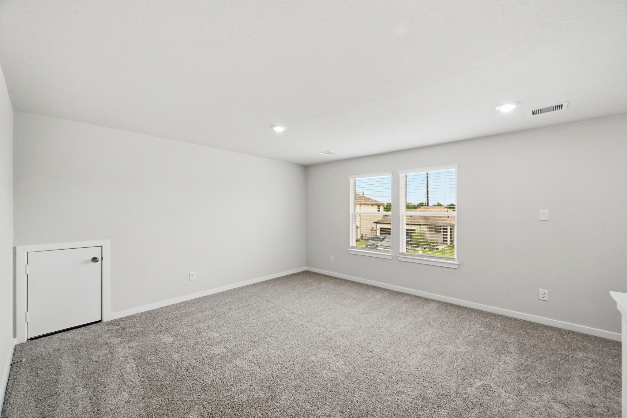 A room with a window and a carpet.