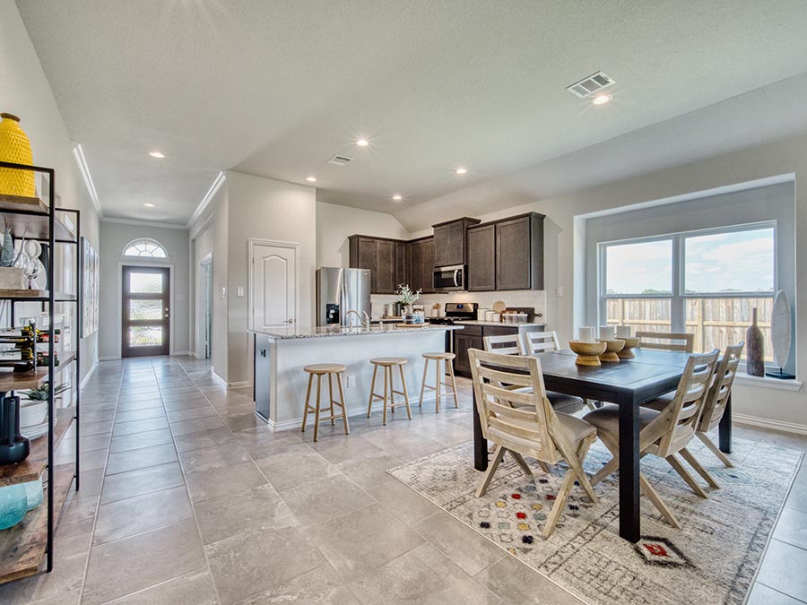 A kitchen with a dining table and chairs.