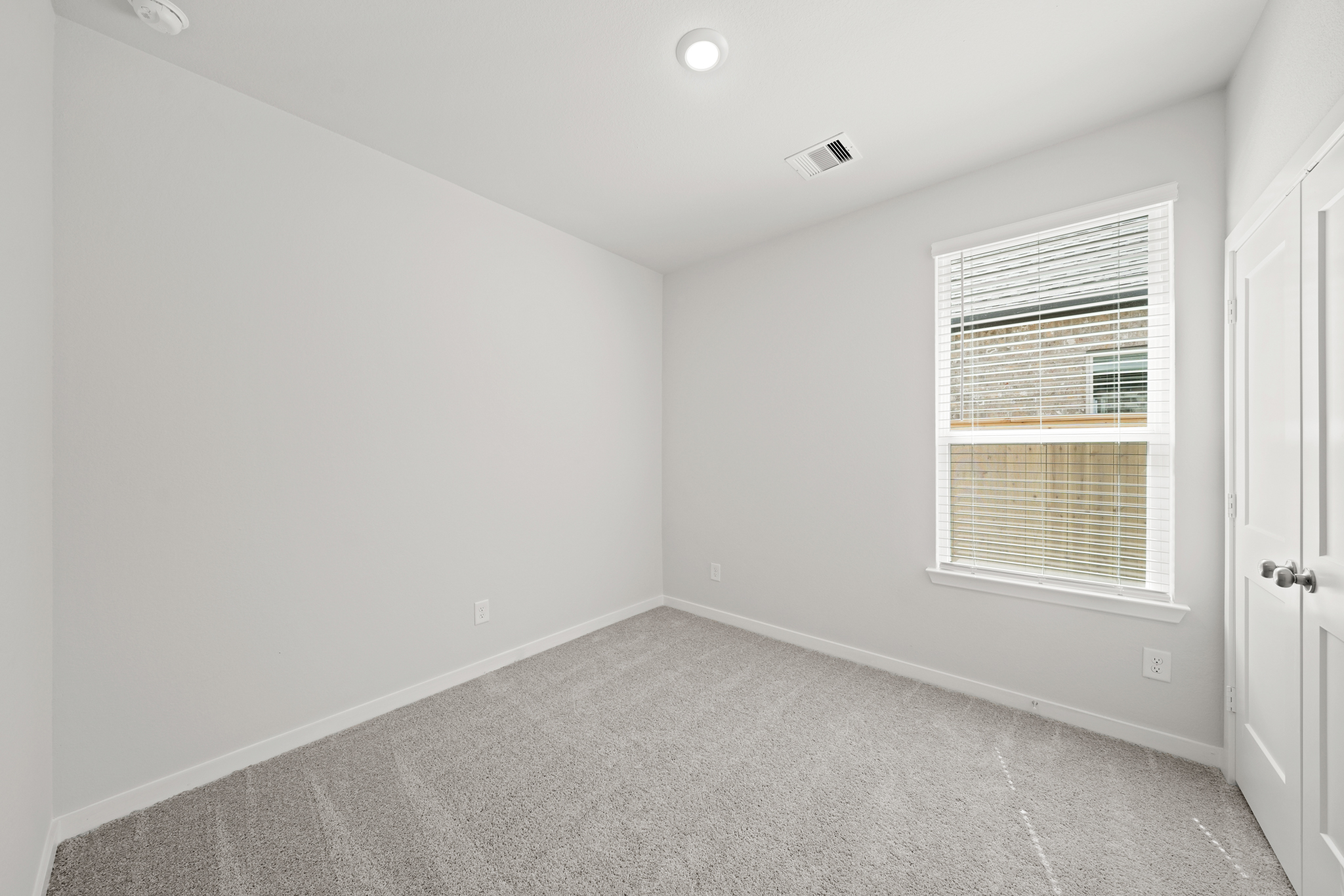 A room with a carpet and a window.