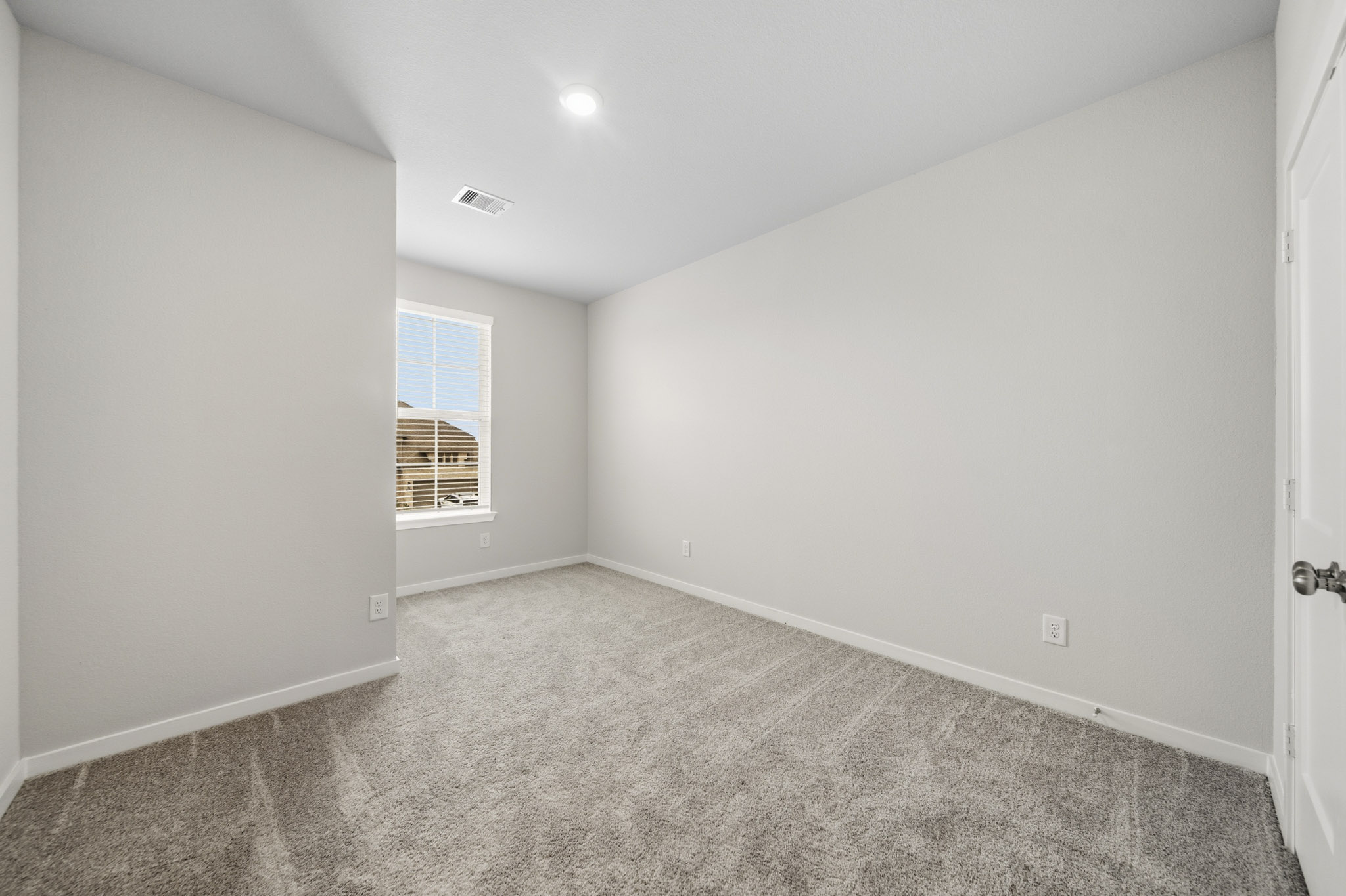 A room with a carpet and windows.