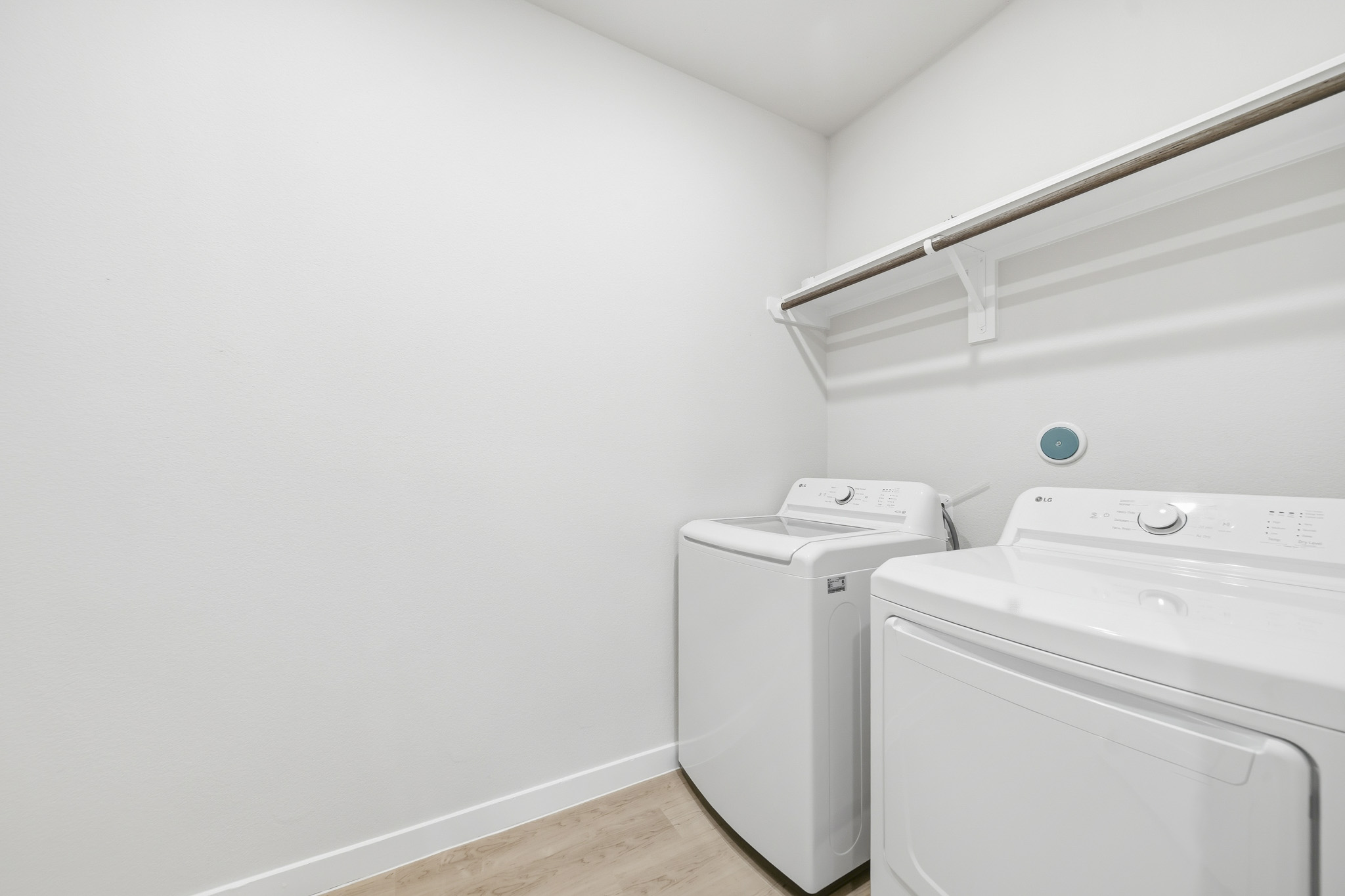 A white laundry room with a white wall.