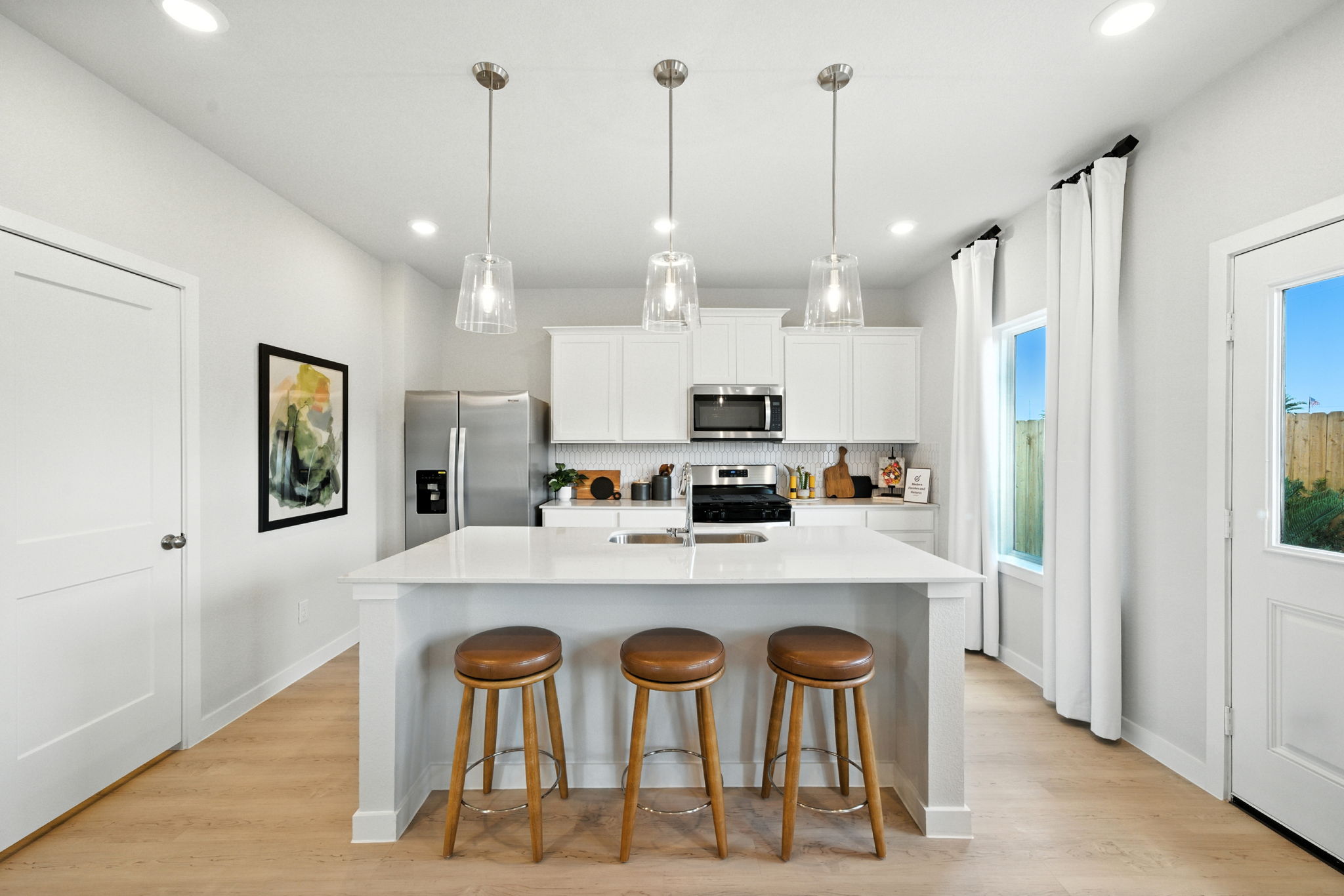 A kitchen with a bar stool and a table.
