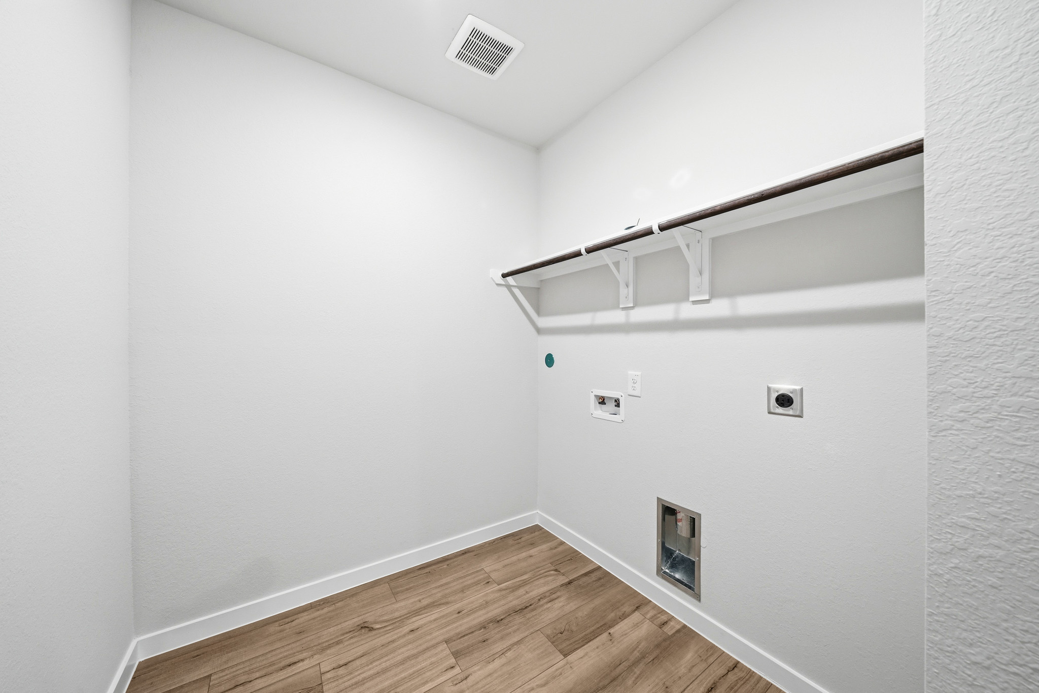 A white room with a wood floor.