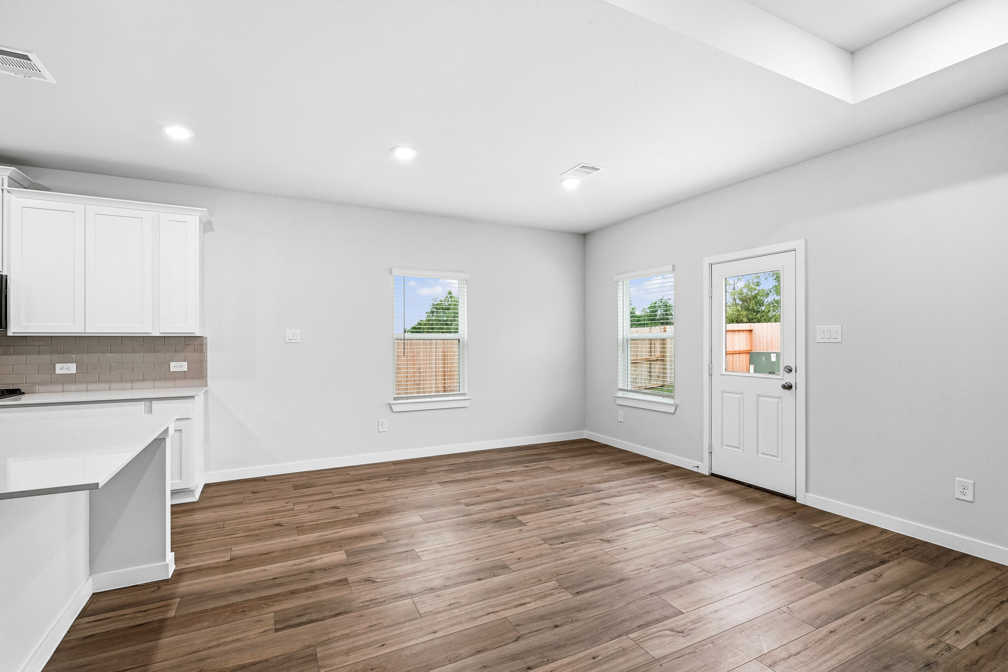 A room with white walls and wood floors.