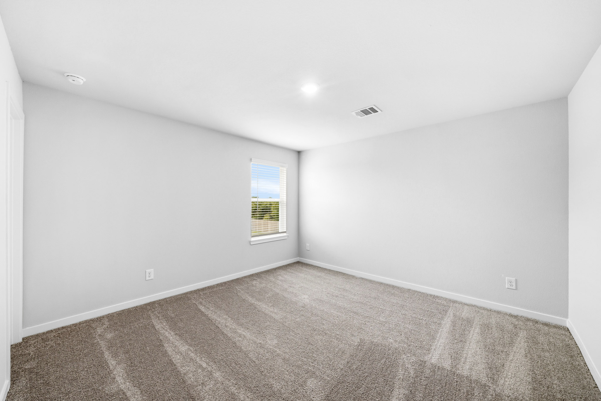 A room with a carpet and a window.