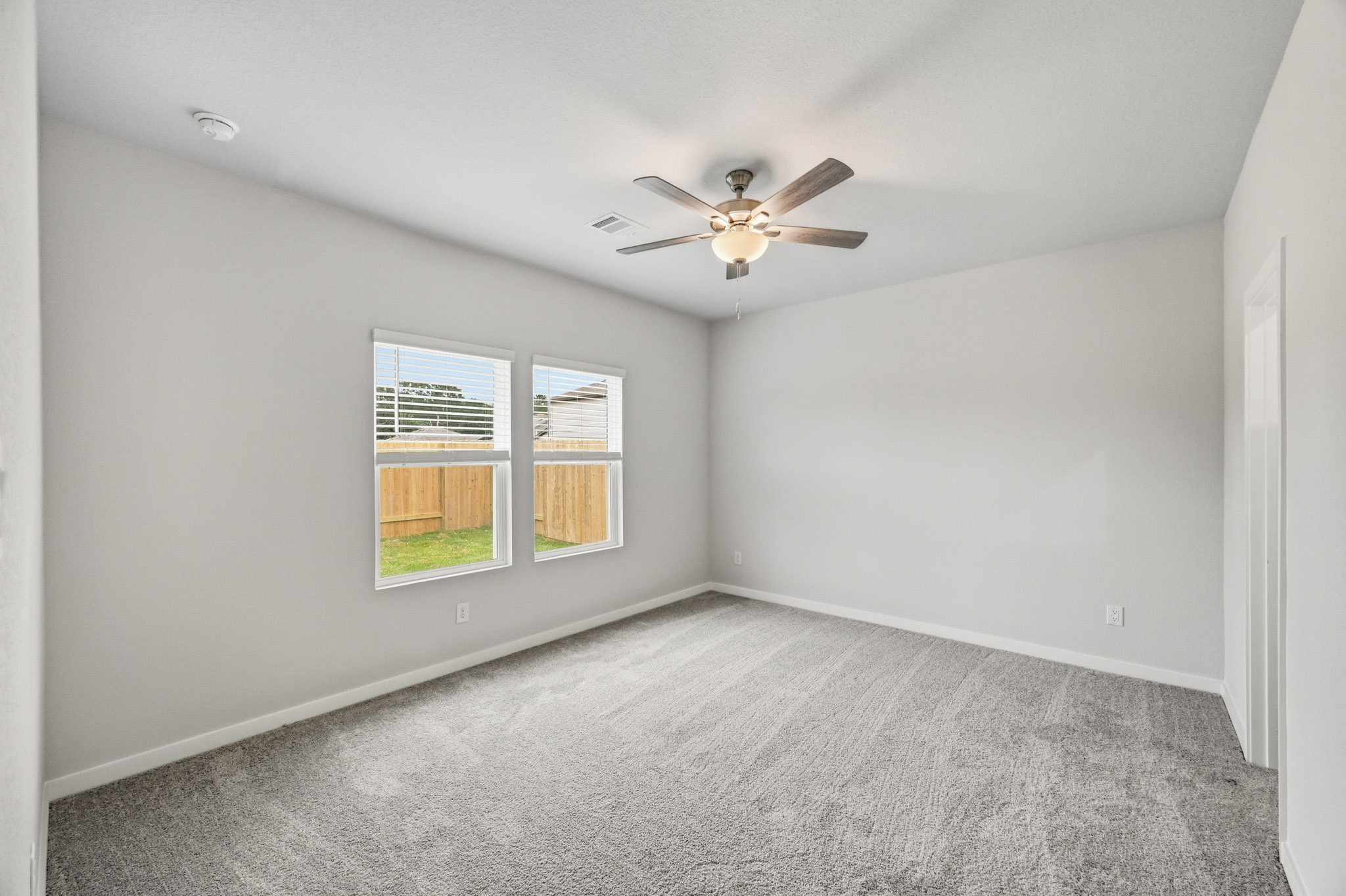 A room with a ceiling fan and a window.