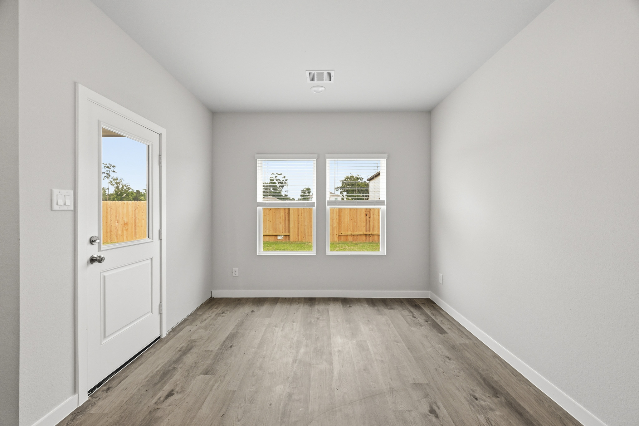 A room with a wood floor and windows.
