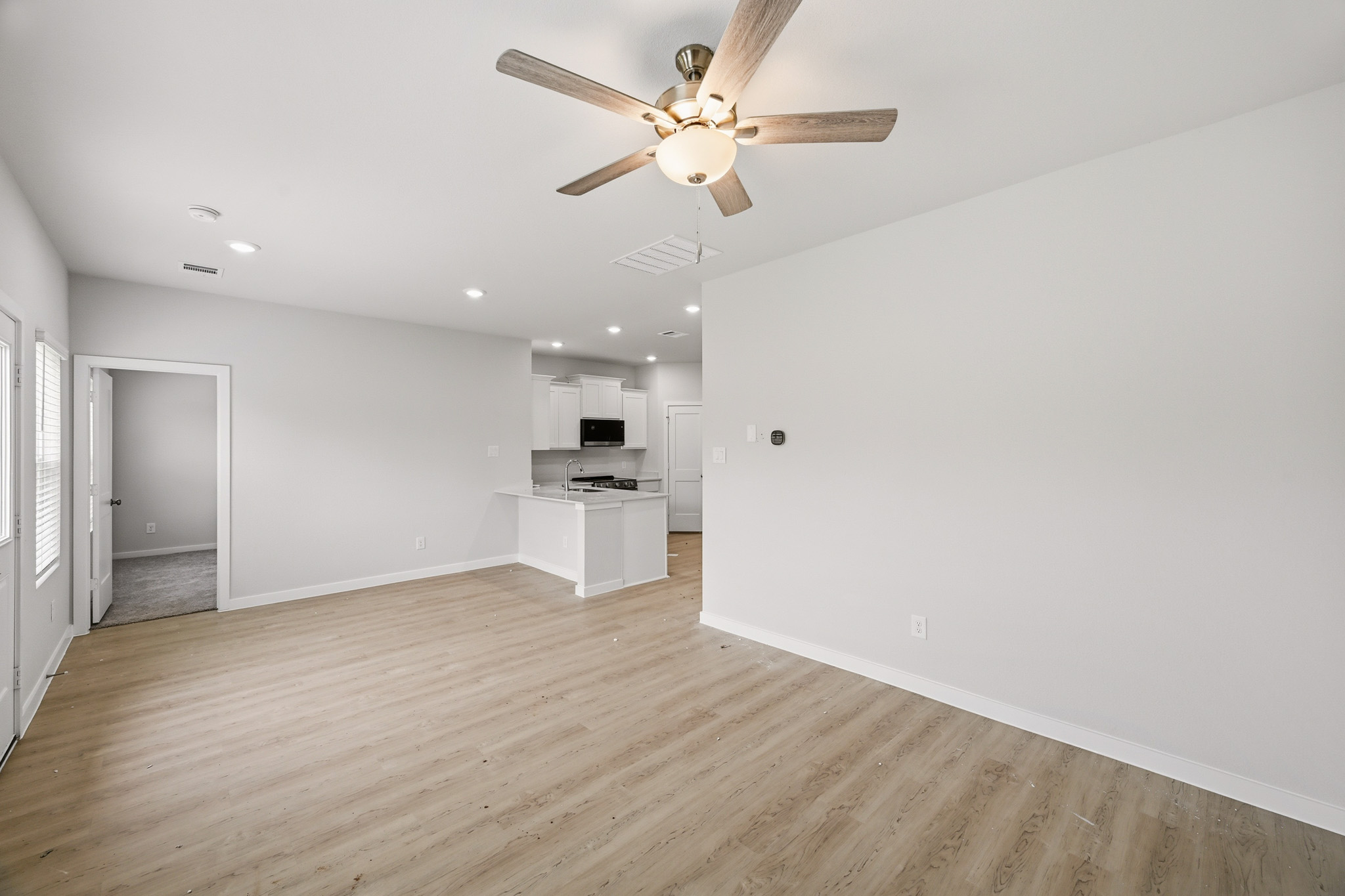 A room with a wood floor and a ceiling fan.