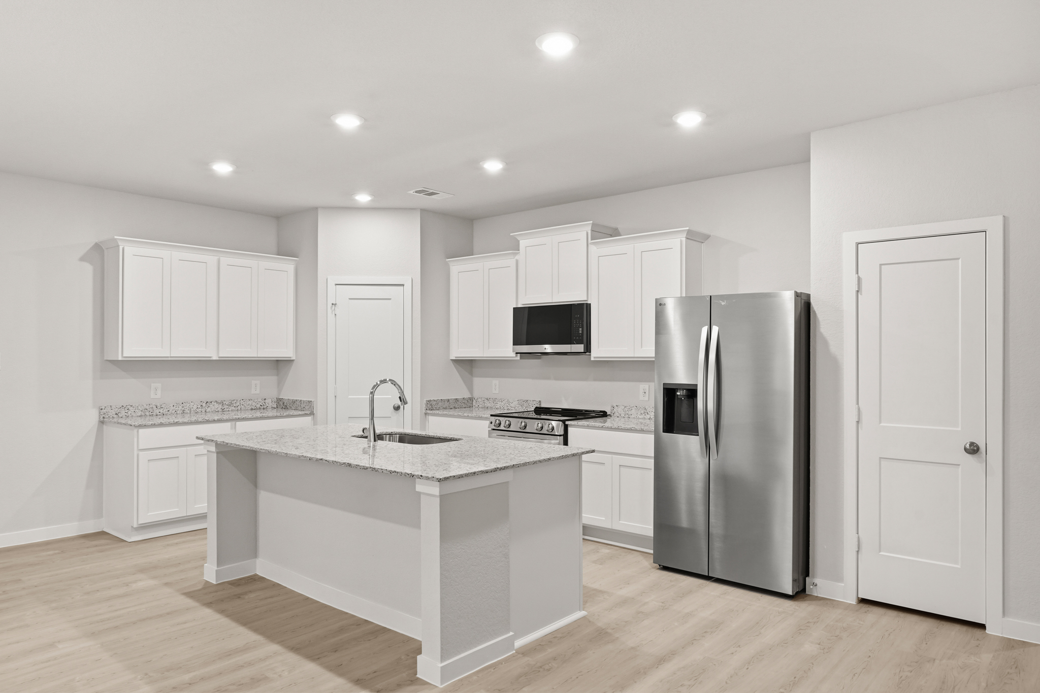 A kitchen with white cabinets.