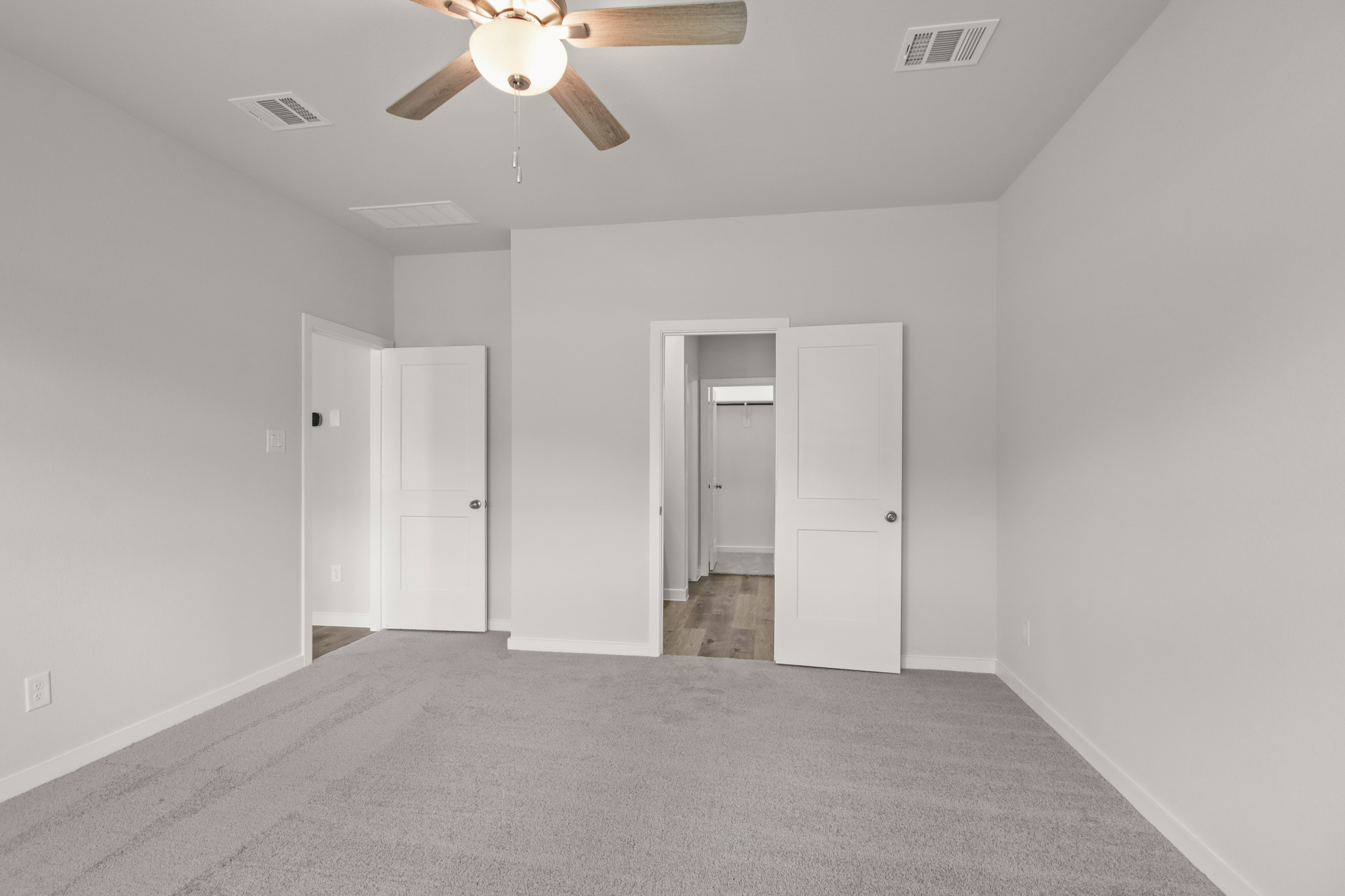A room with white doors and a ceiling fan.