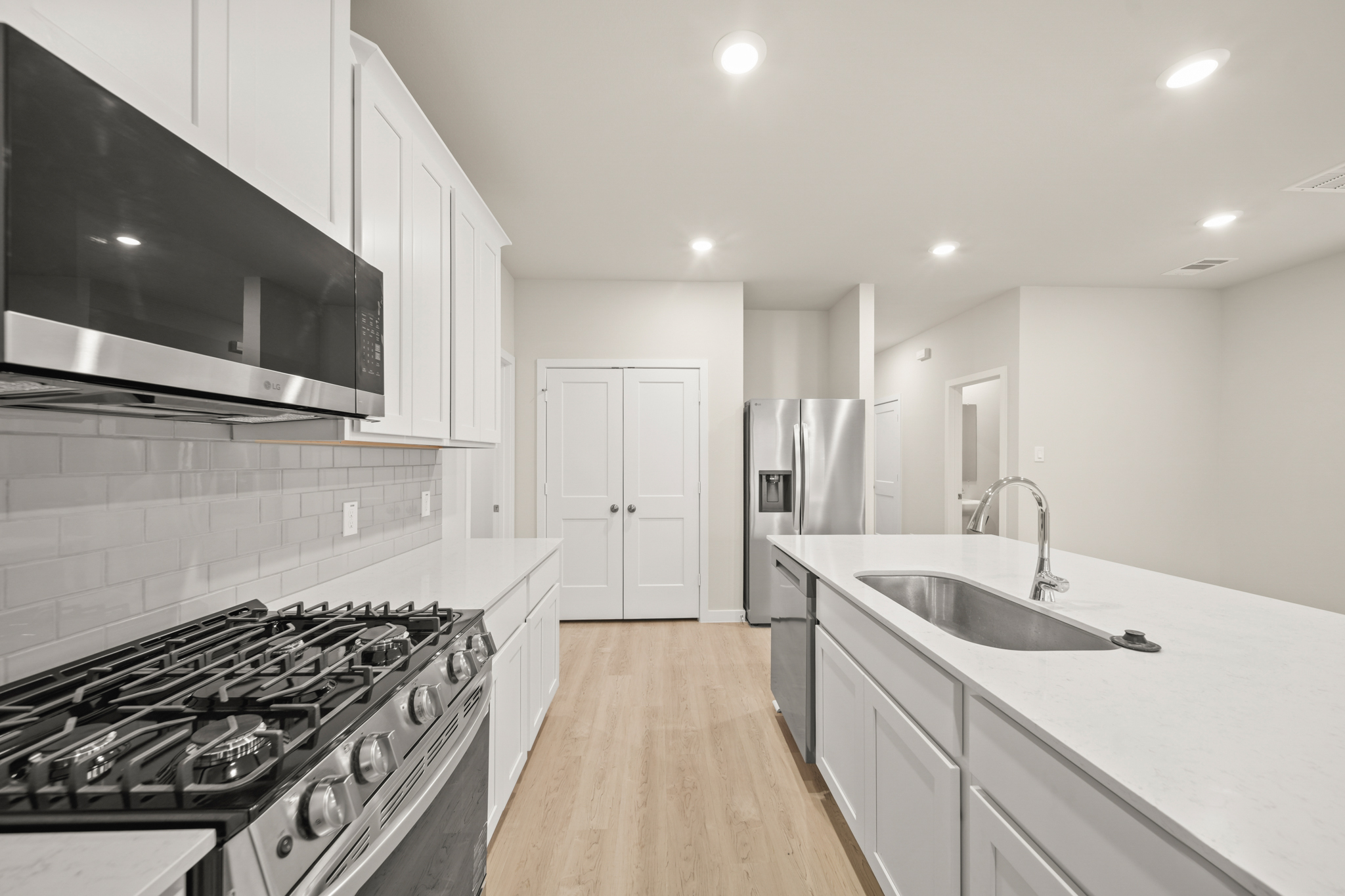 A kitchen with white cabinets.