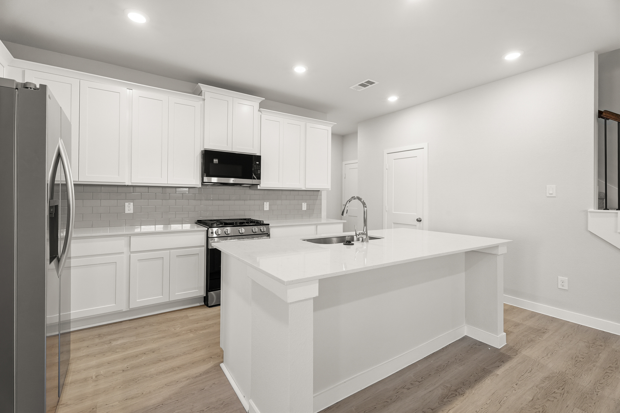 A kitchen with white cabinets.