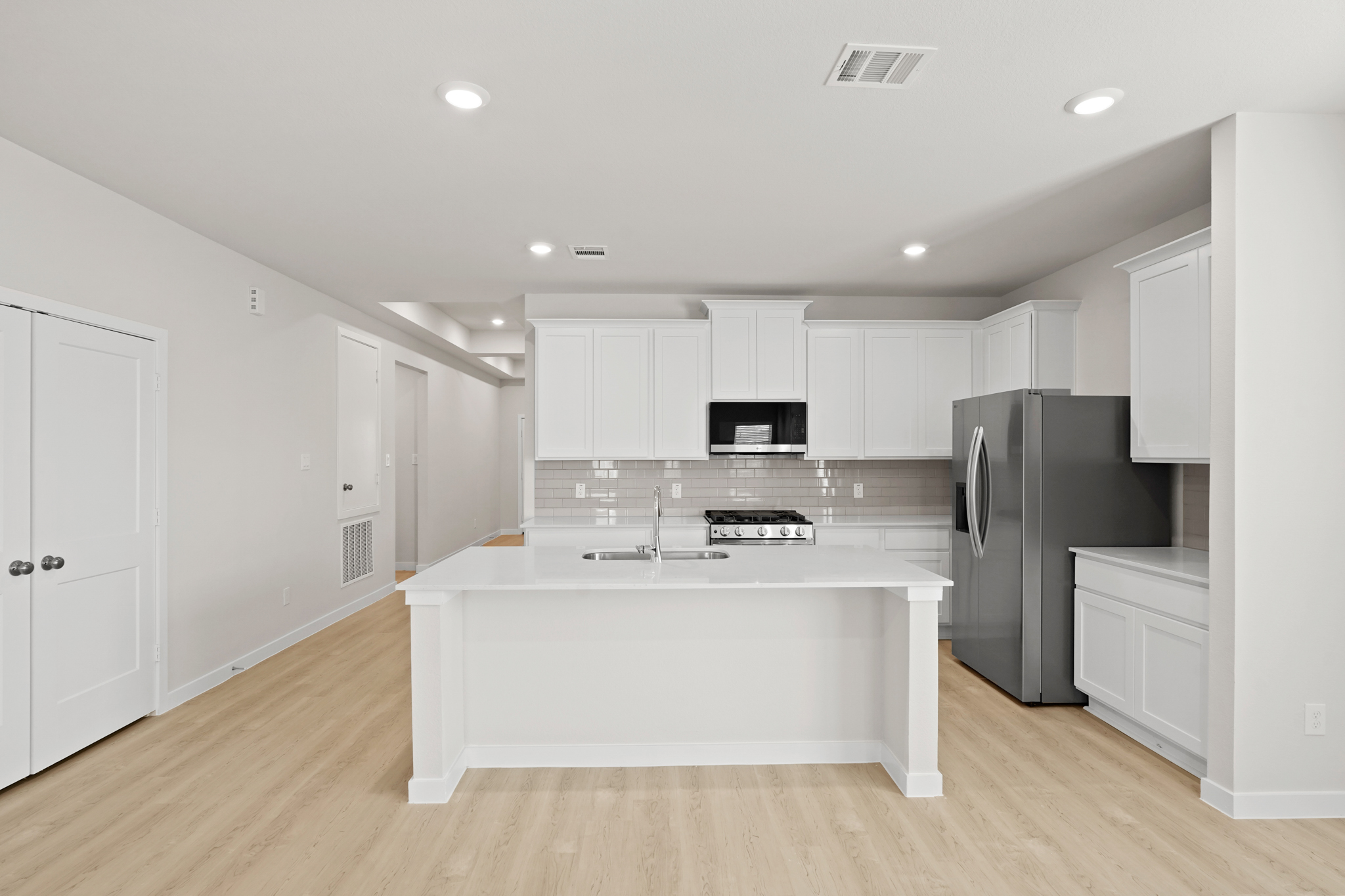 A kitchen with white cabinets.