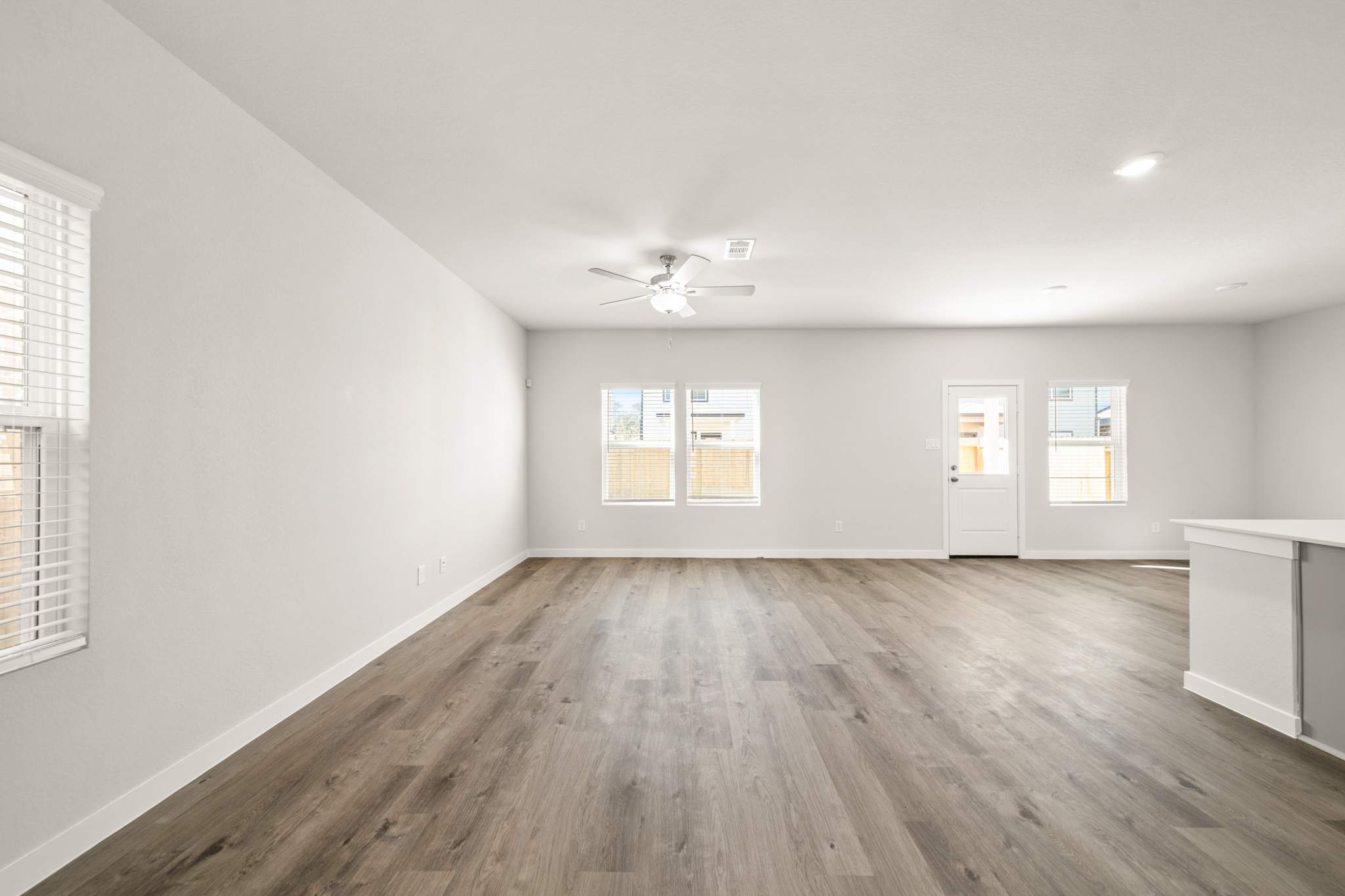 A room with a wood floor and a ceiling fan.