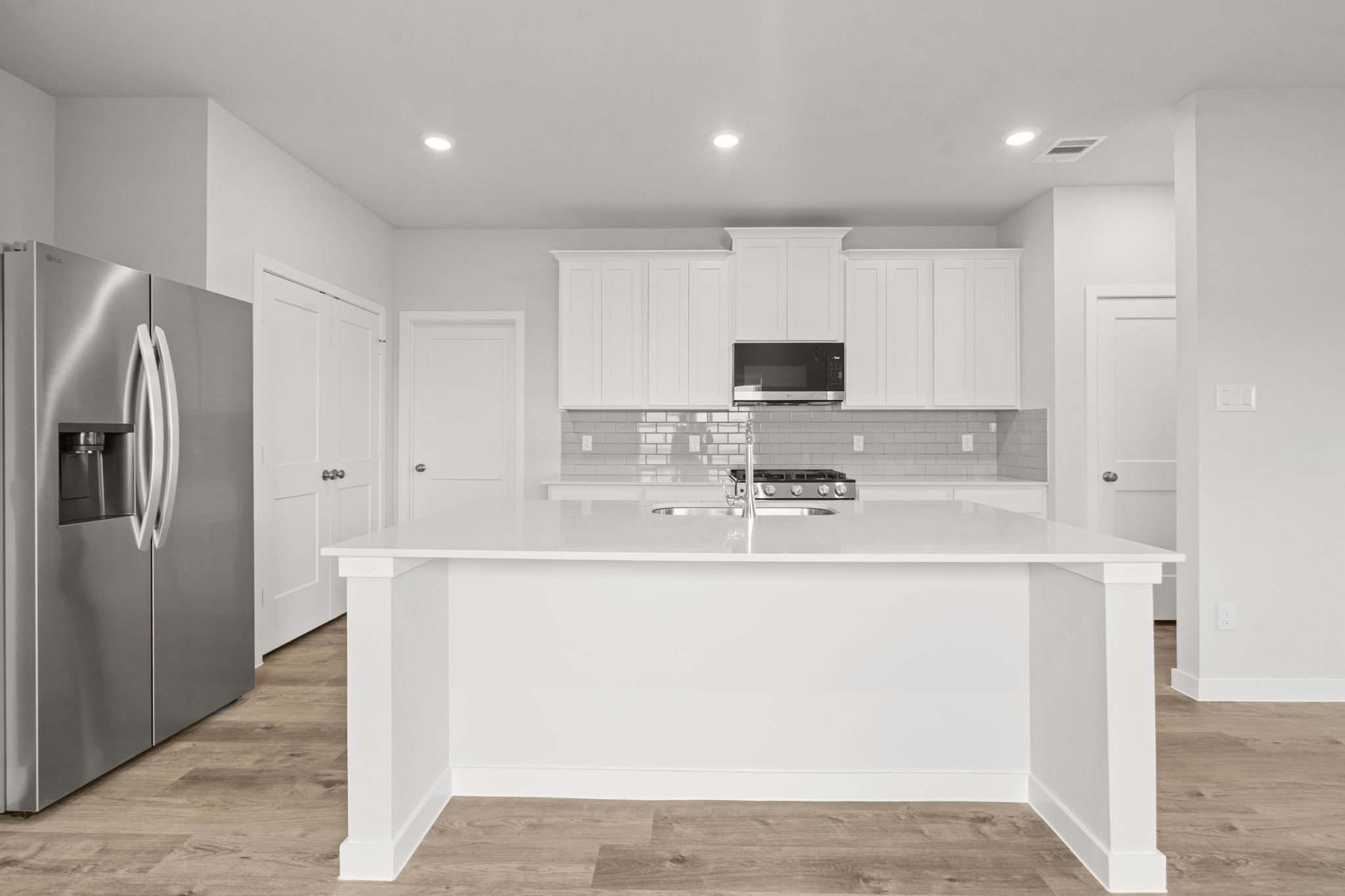 A kitchen with white cabinets.