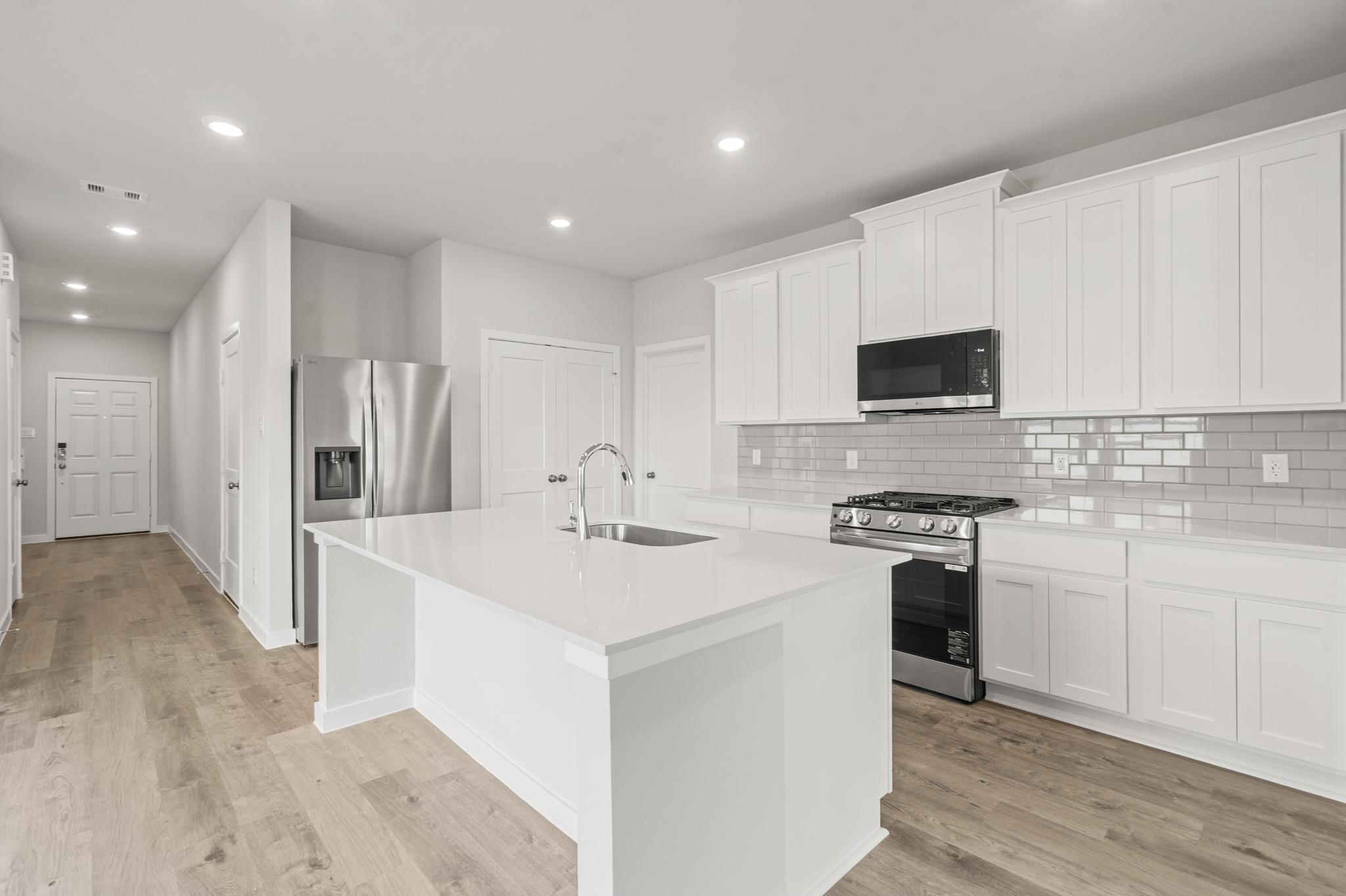 A kitchen with white cabinets.