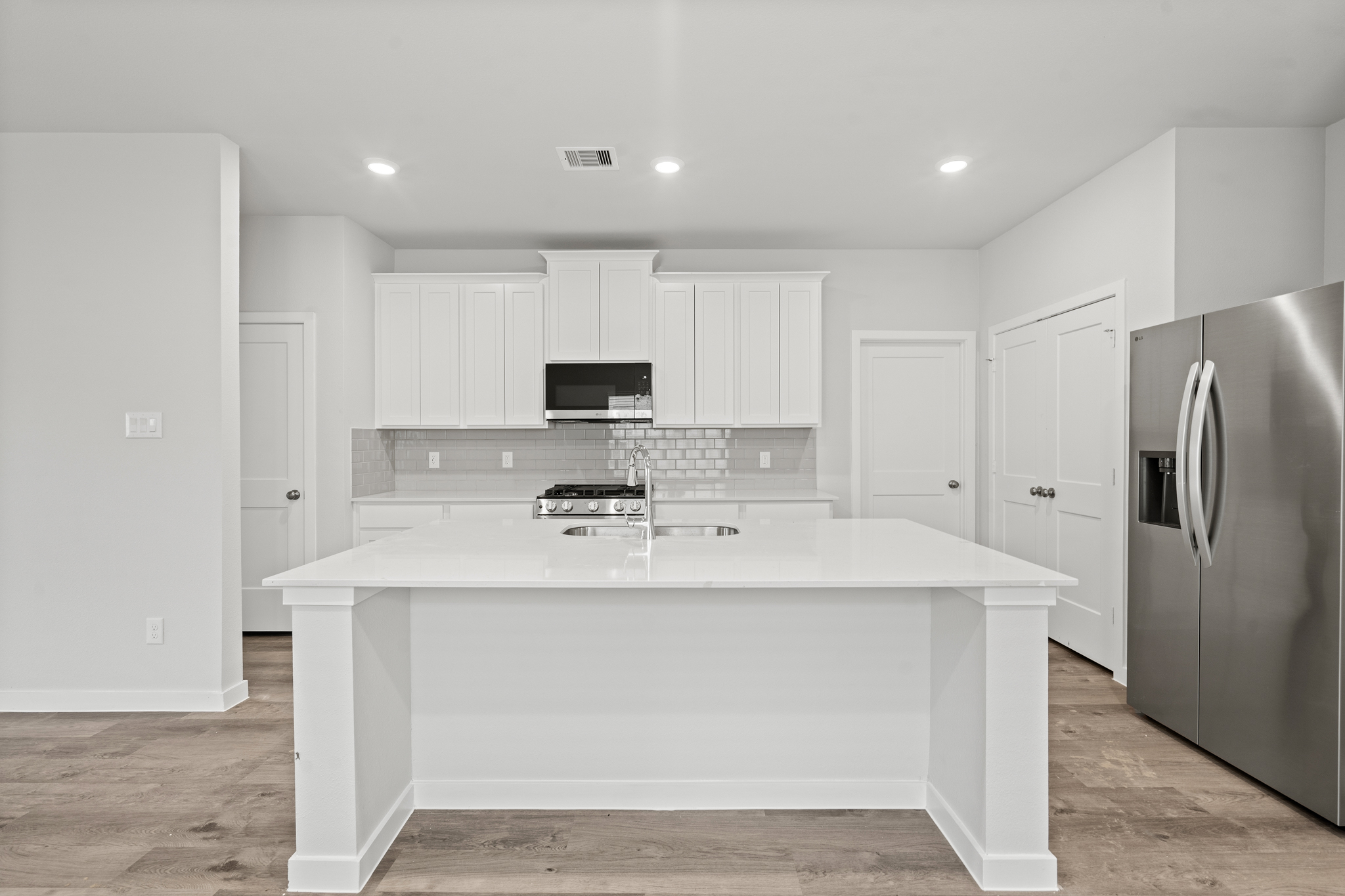 A kitchen with white cabinets.