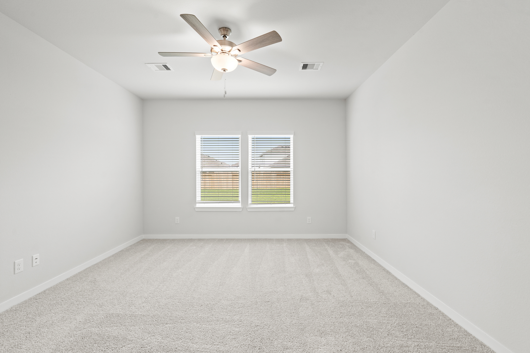 A room with a ceiling fan and a window.