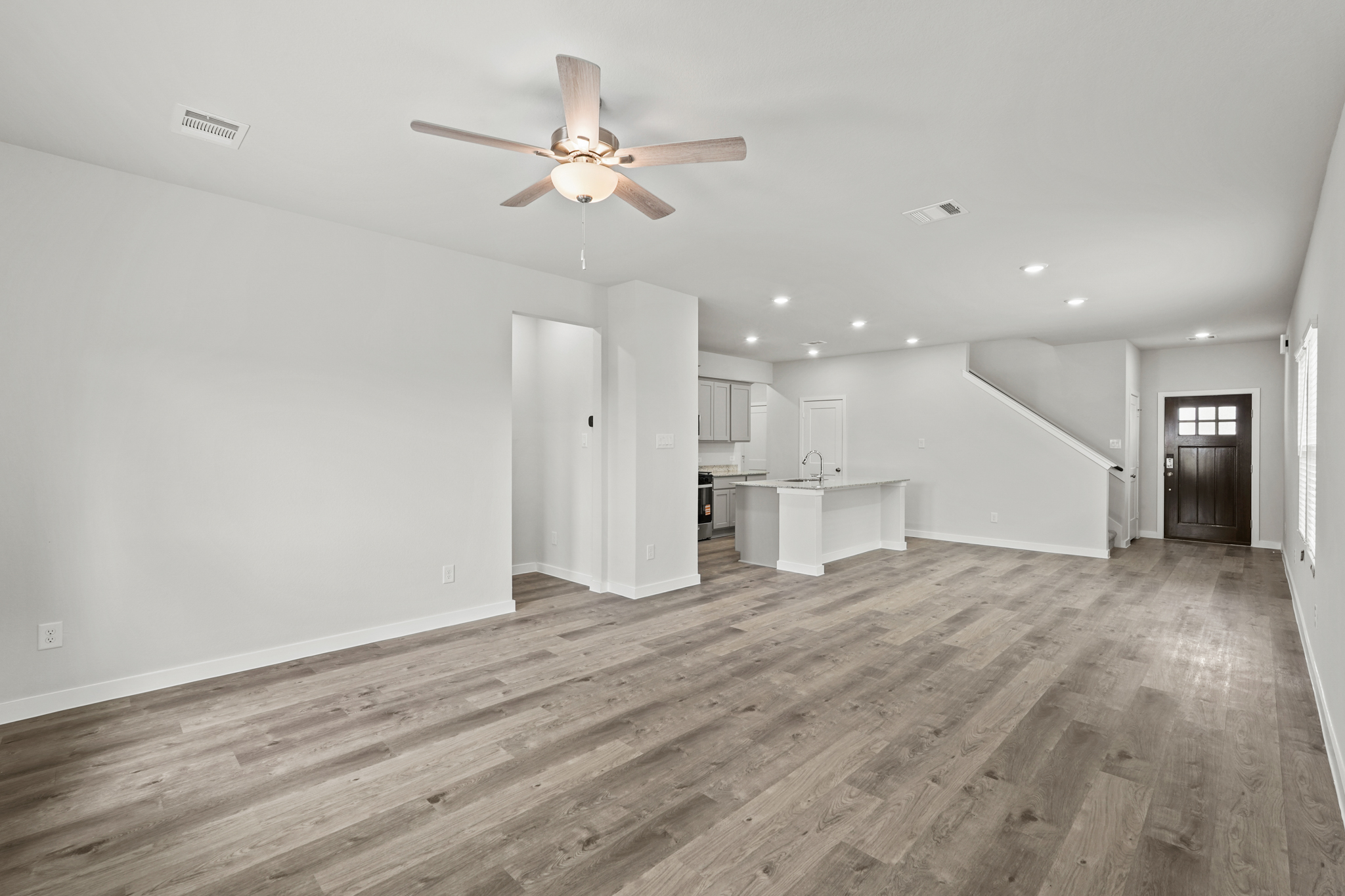 A room with a wood floor and a ceiling fan.
