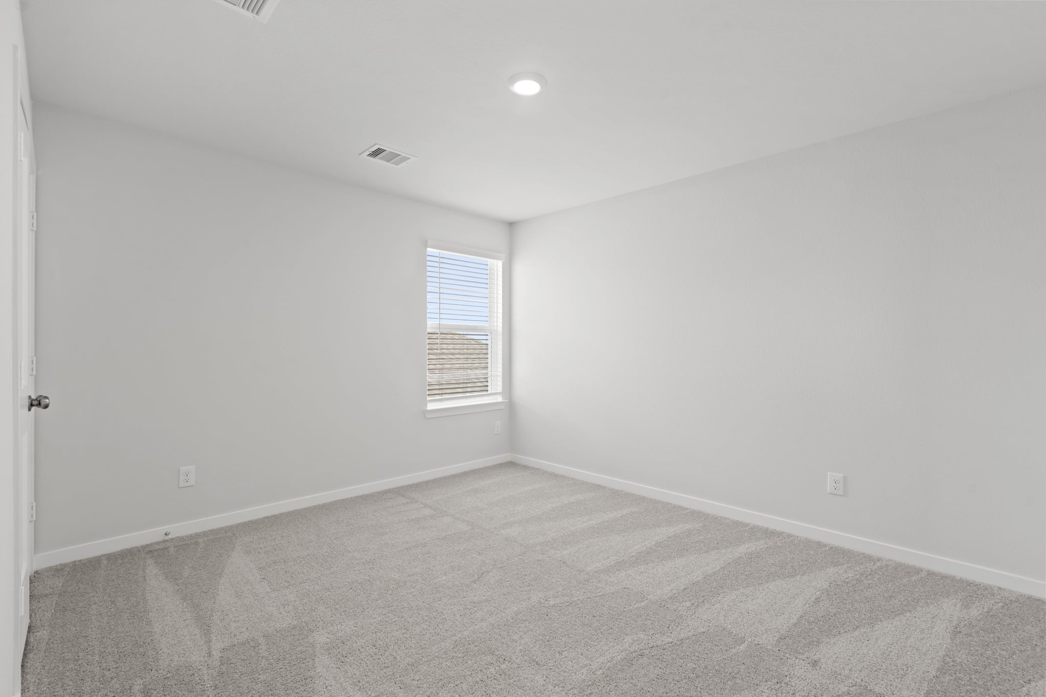 A room with a carpet and a window.