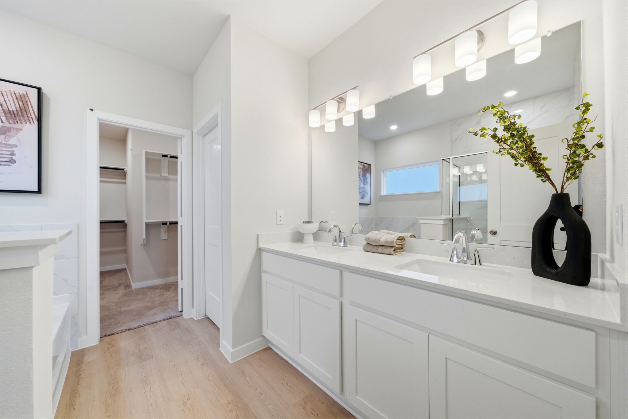 A bathroom with white cabinets.