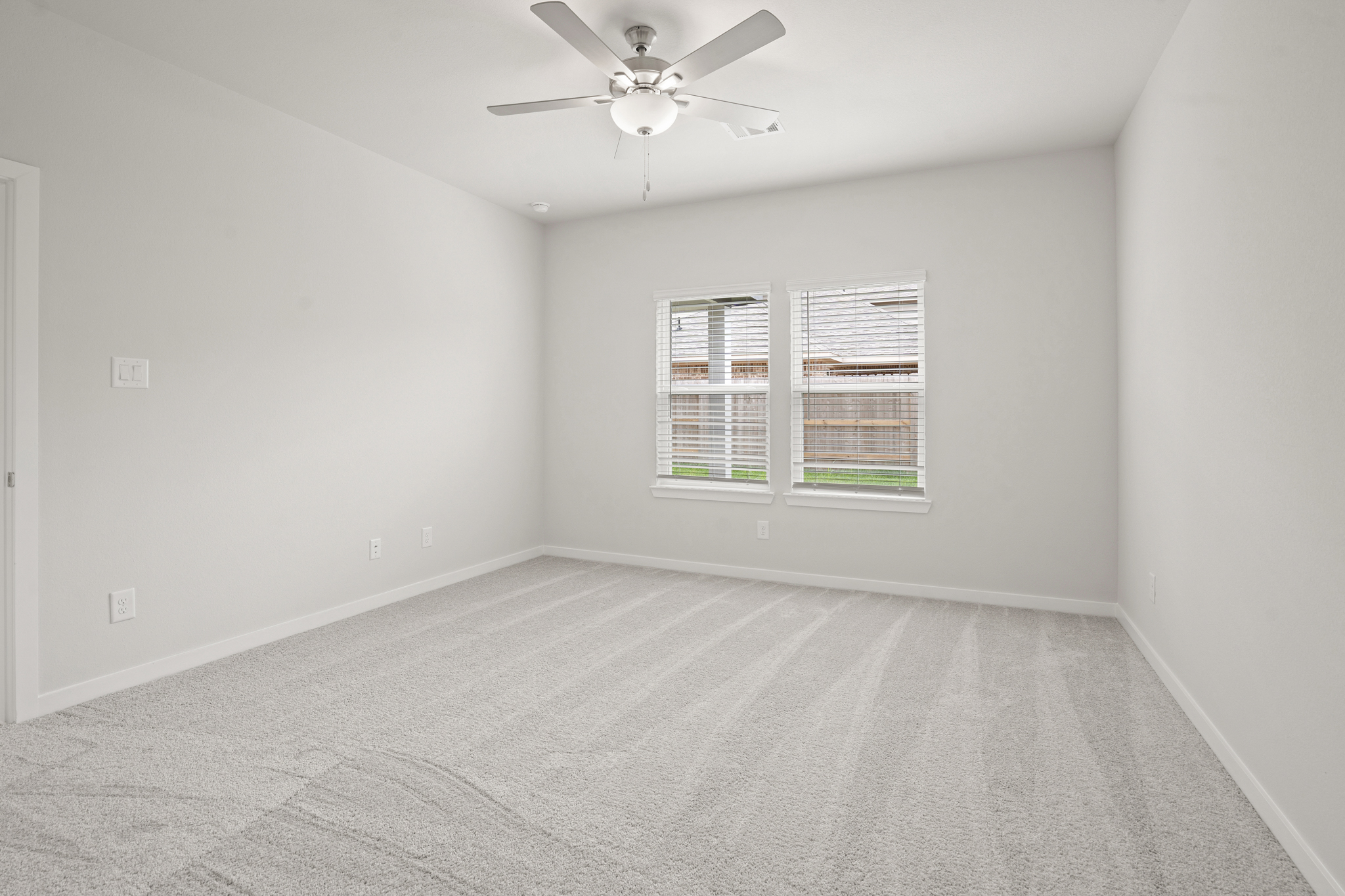 A room with a ceiling fan and a window.