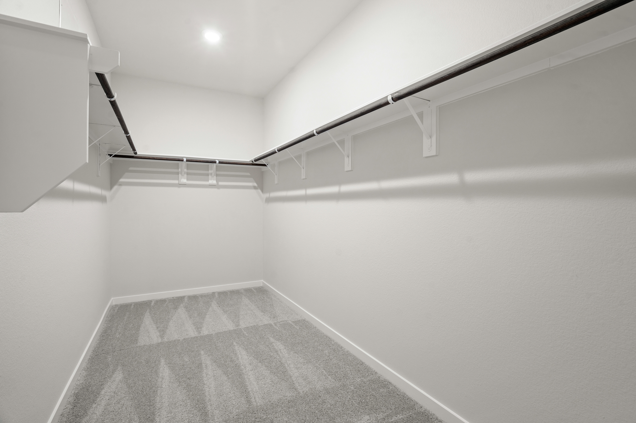 A white hallway with a grey carpet.