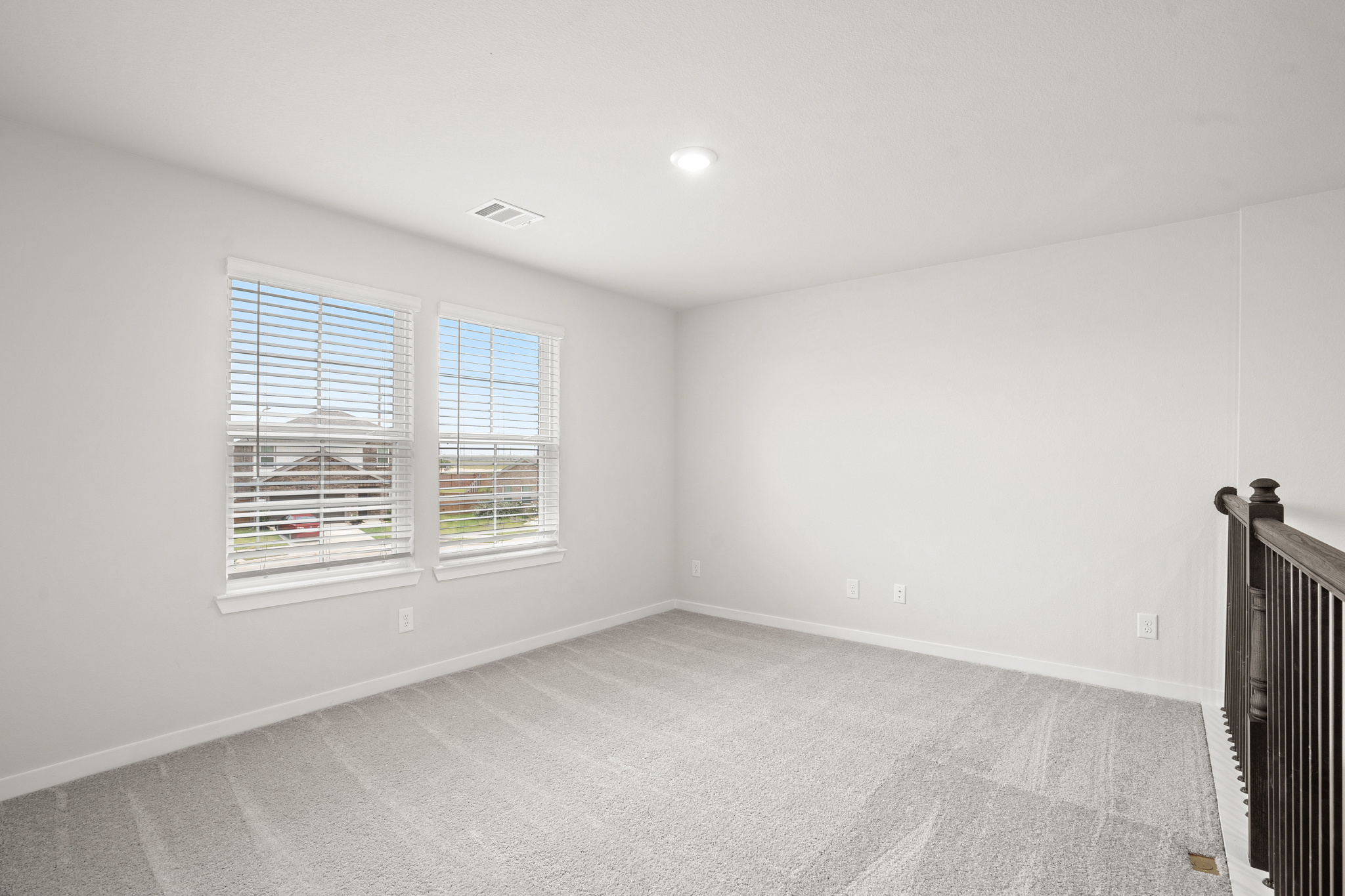 A room with a window and a rug.