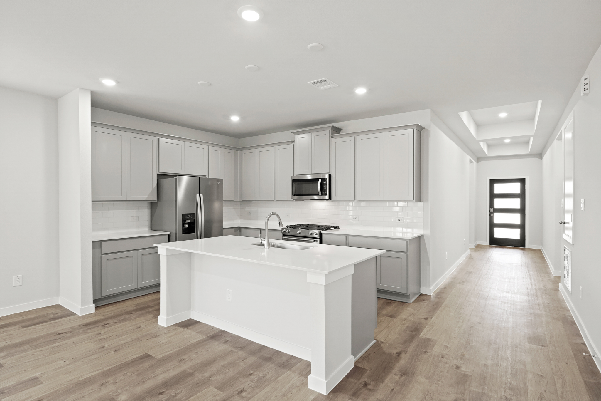 A kitchen with white cabinets.