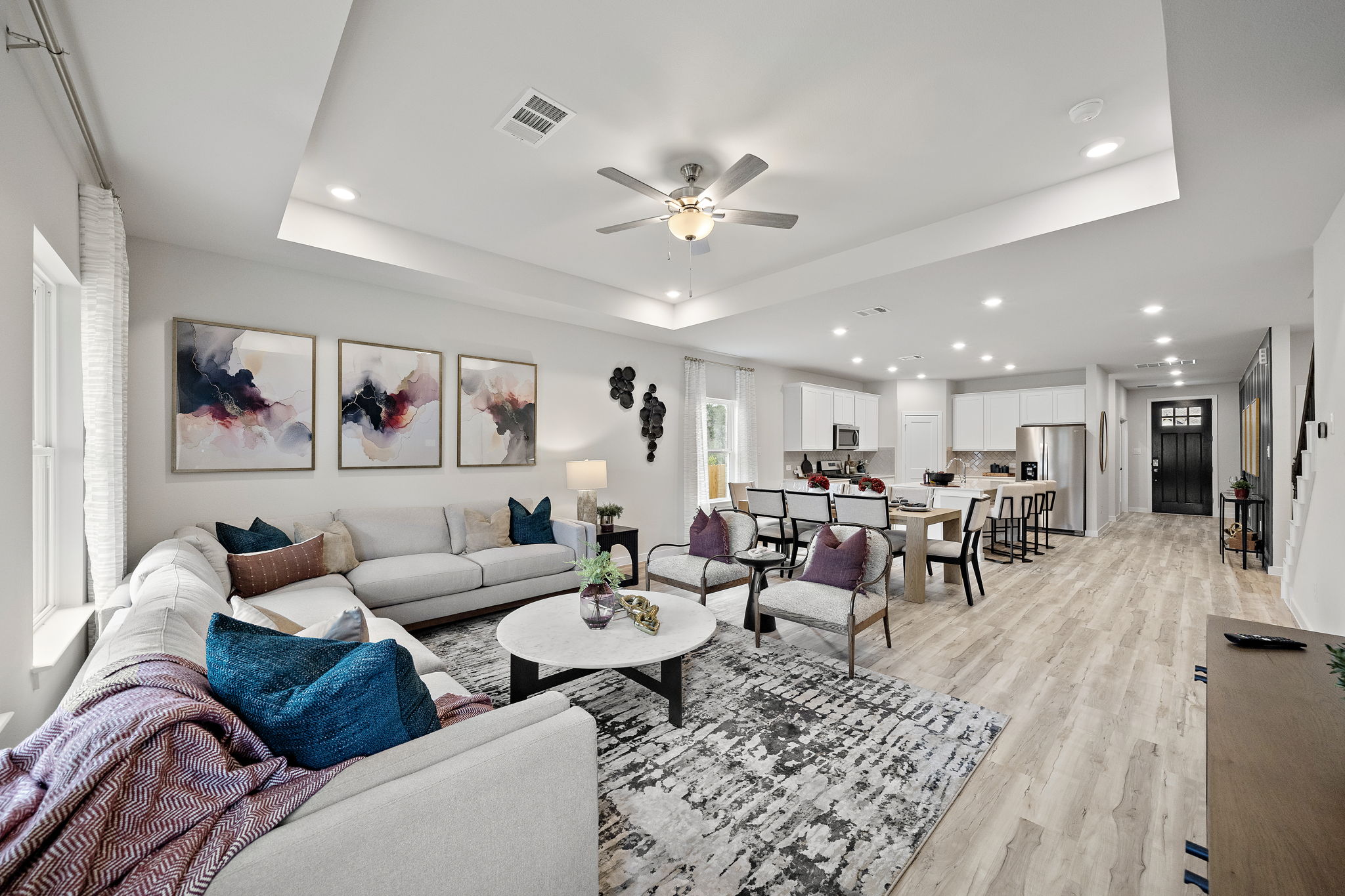 A living room with a large chandelier and a large white couch.