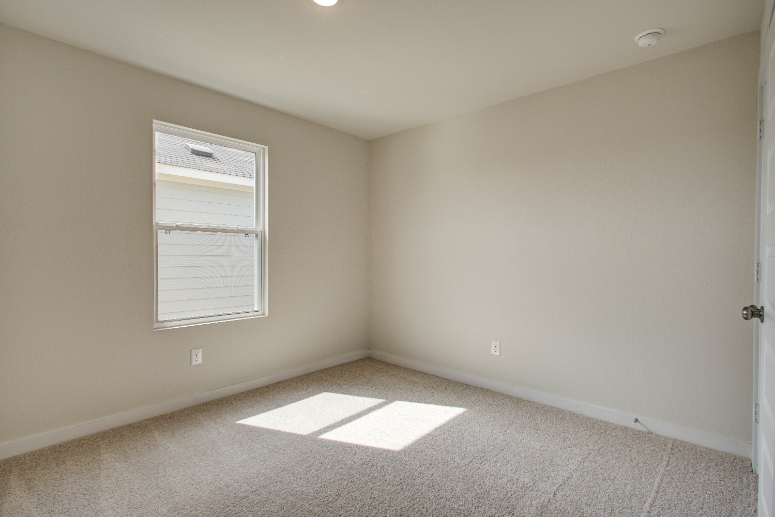 A room with a door and a rug.