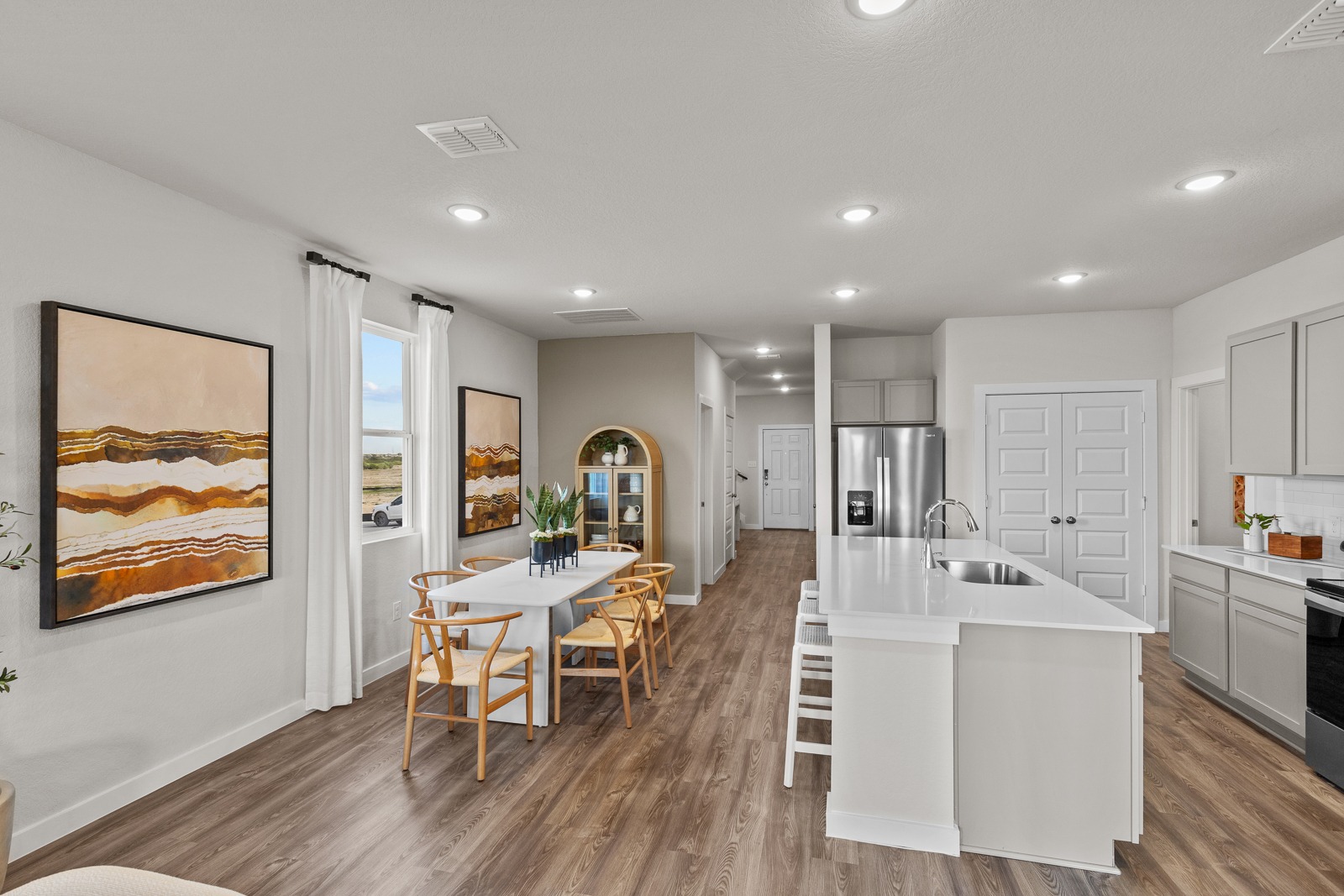 A kitchen with a dining table and a painting on the wall.