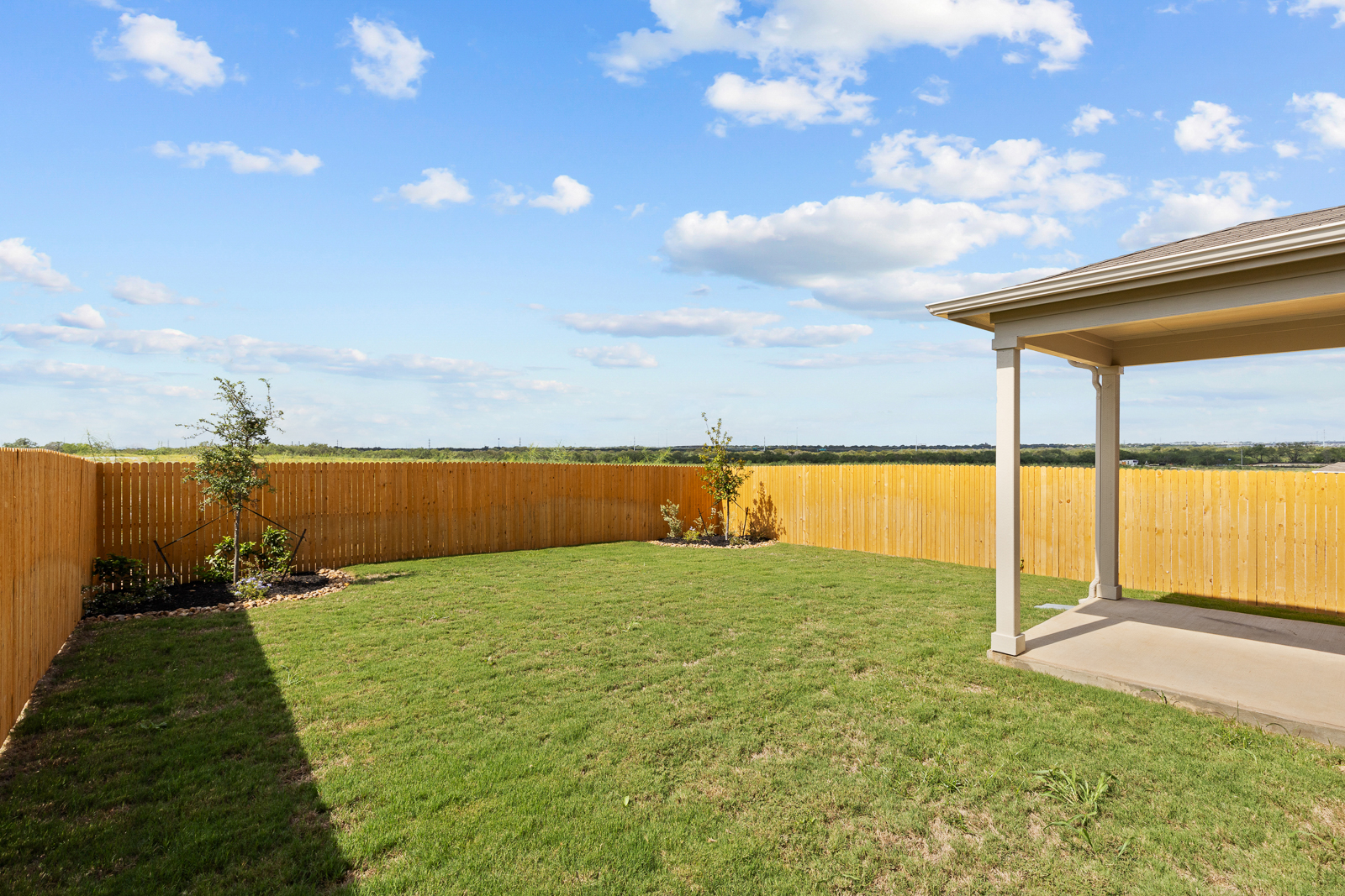 A fenced in yard with a wood building and a wood fence.
