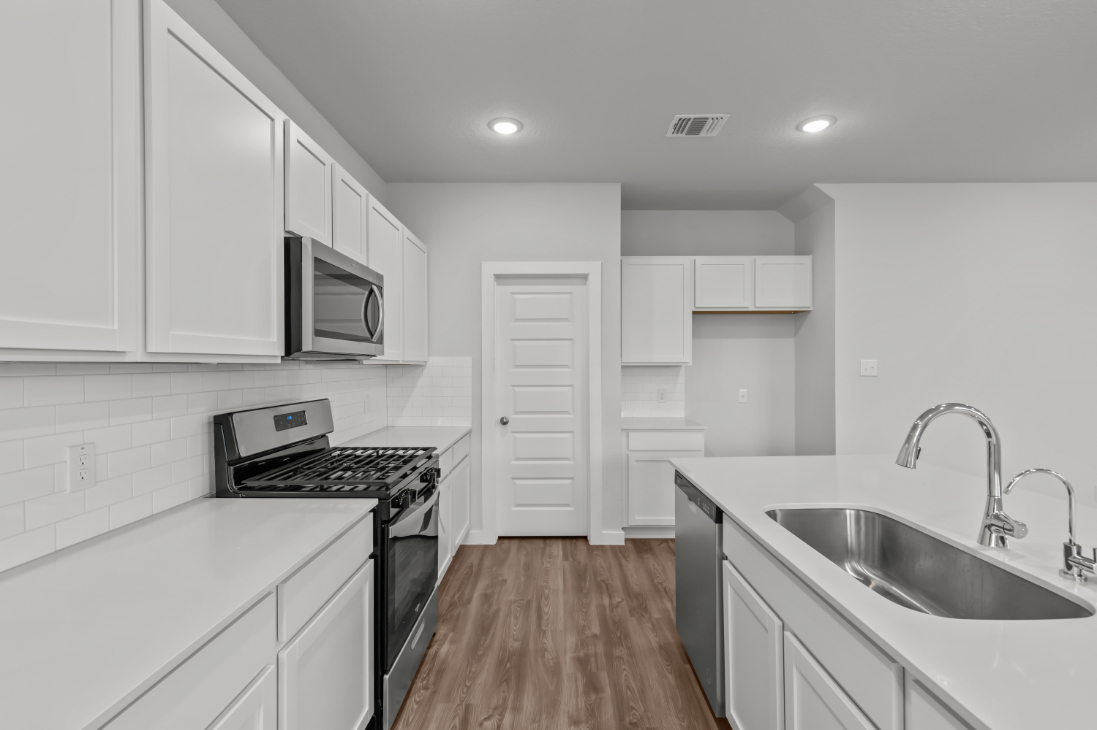 A kitchen with white cabinets.