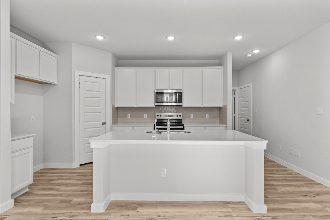 A kitchen with white cabinets.
