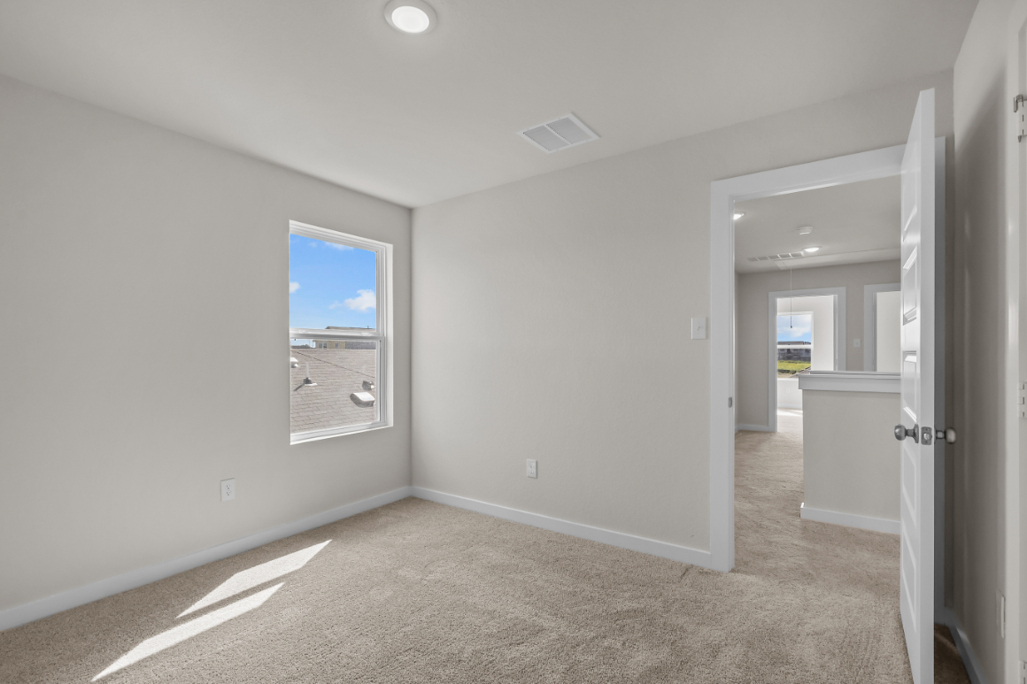 A room with a carpet and a door.