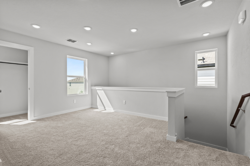 A room with a white bench and a white wall.