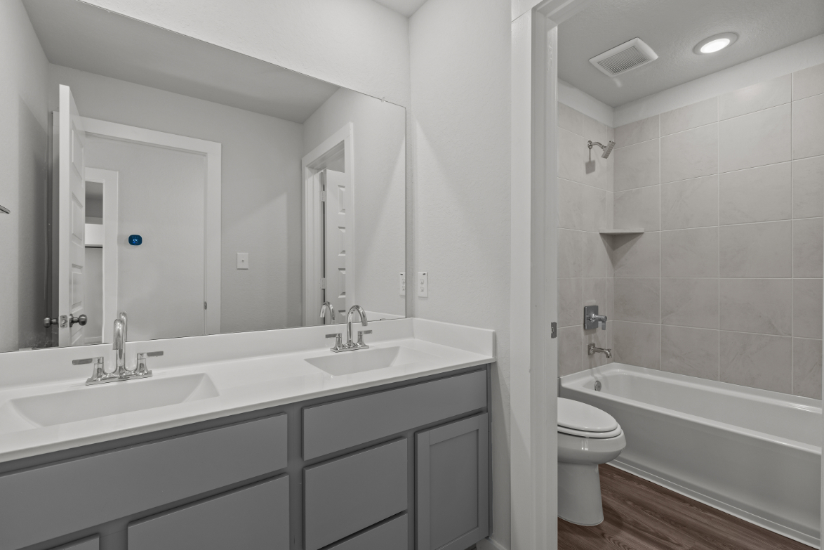 A bathroom with a tub sink and toilet.