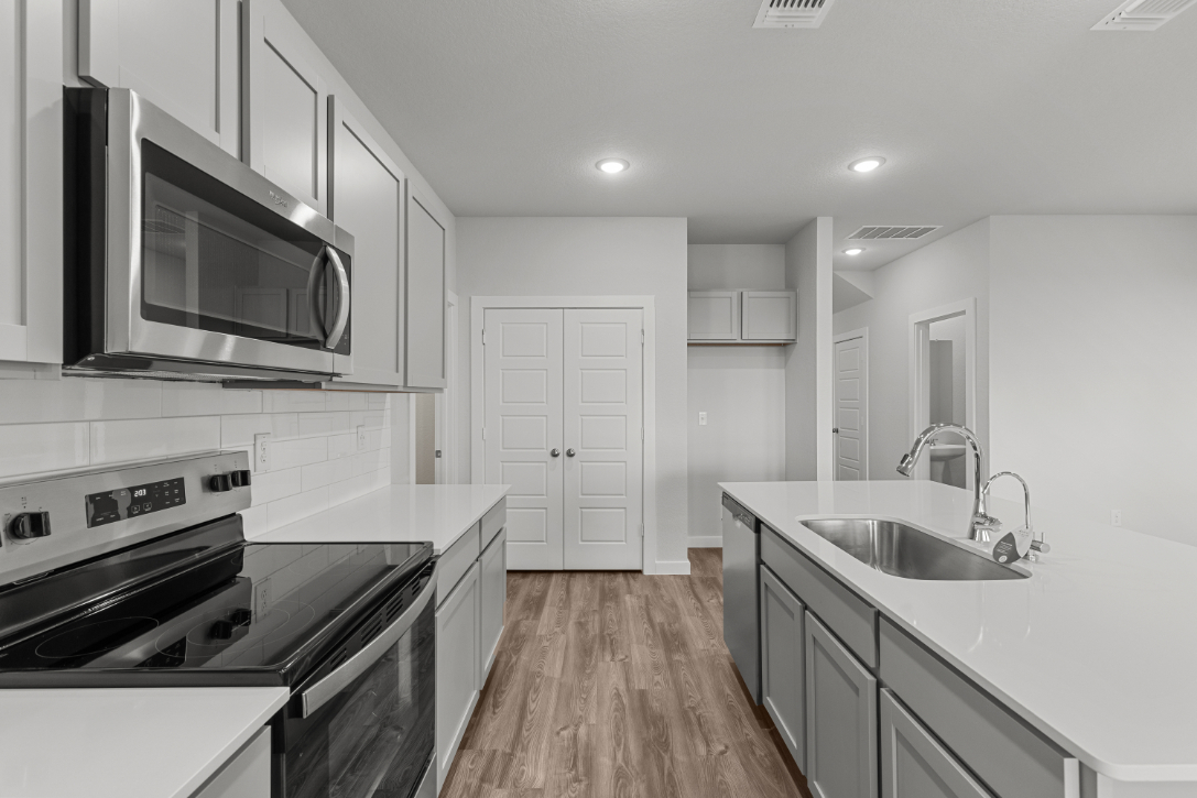 A kitchen with white cabinets.