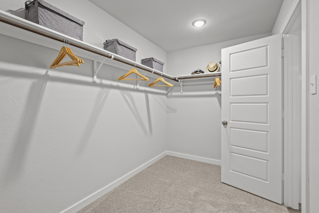 A room with white walls and a white door with yellow tape on it.