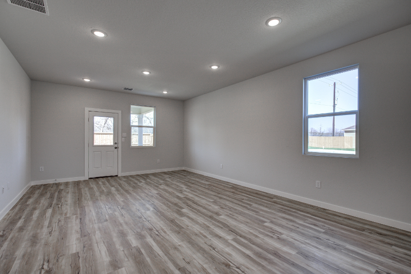 A room with a wood floor and windows.