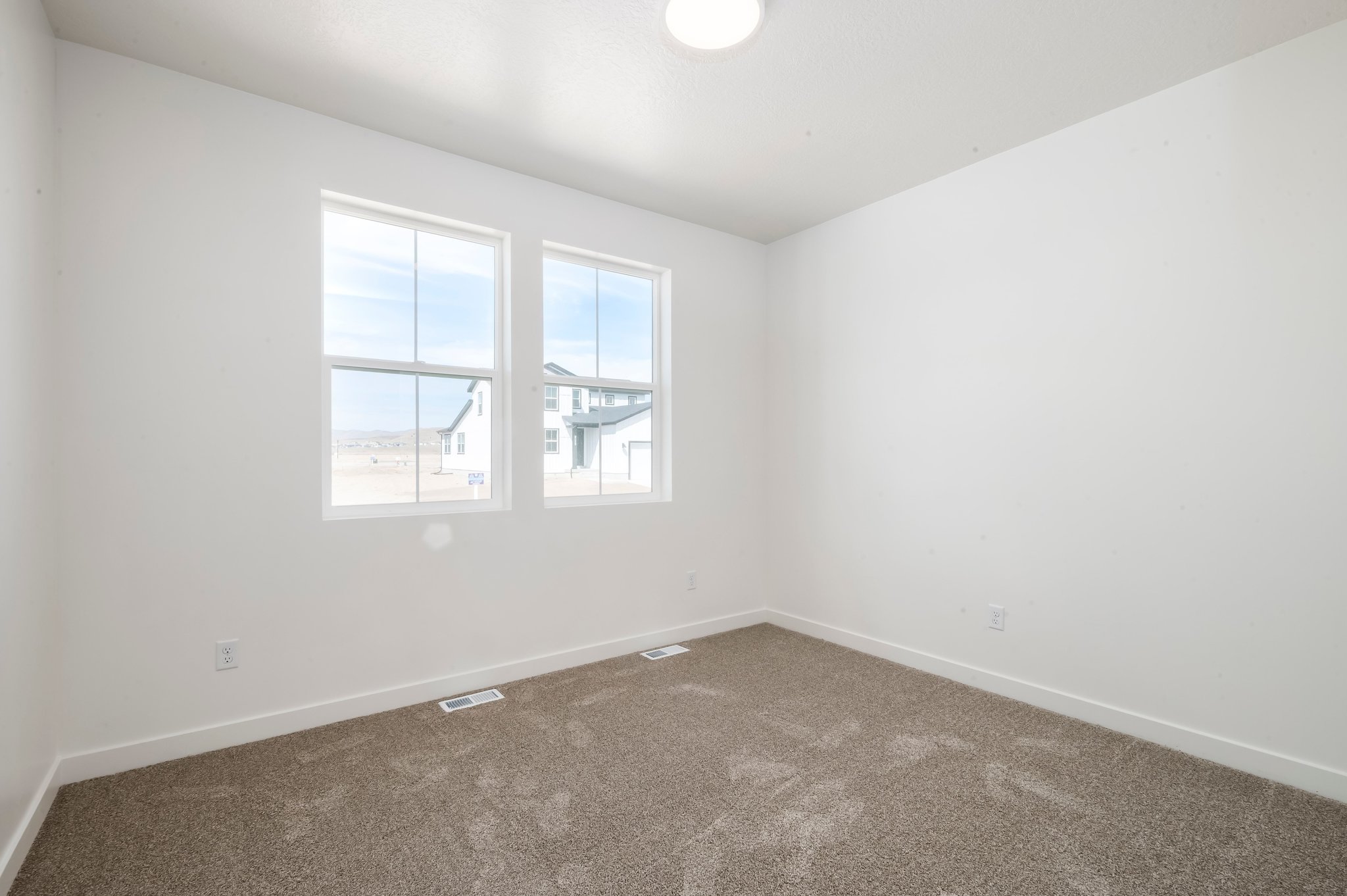 A room with a window and carpet.
