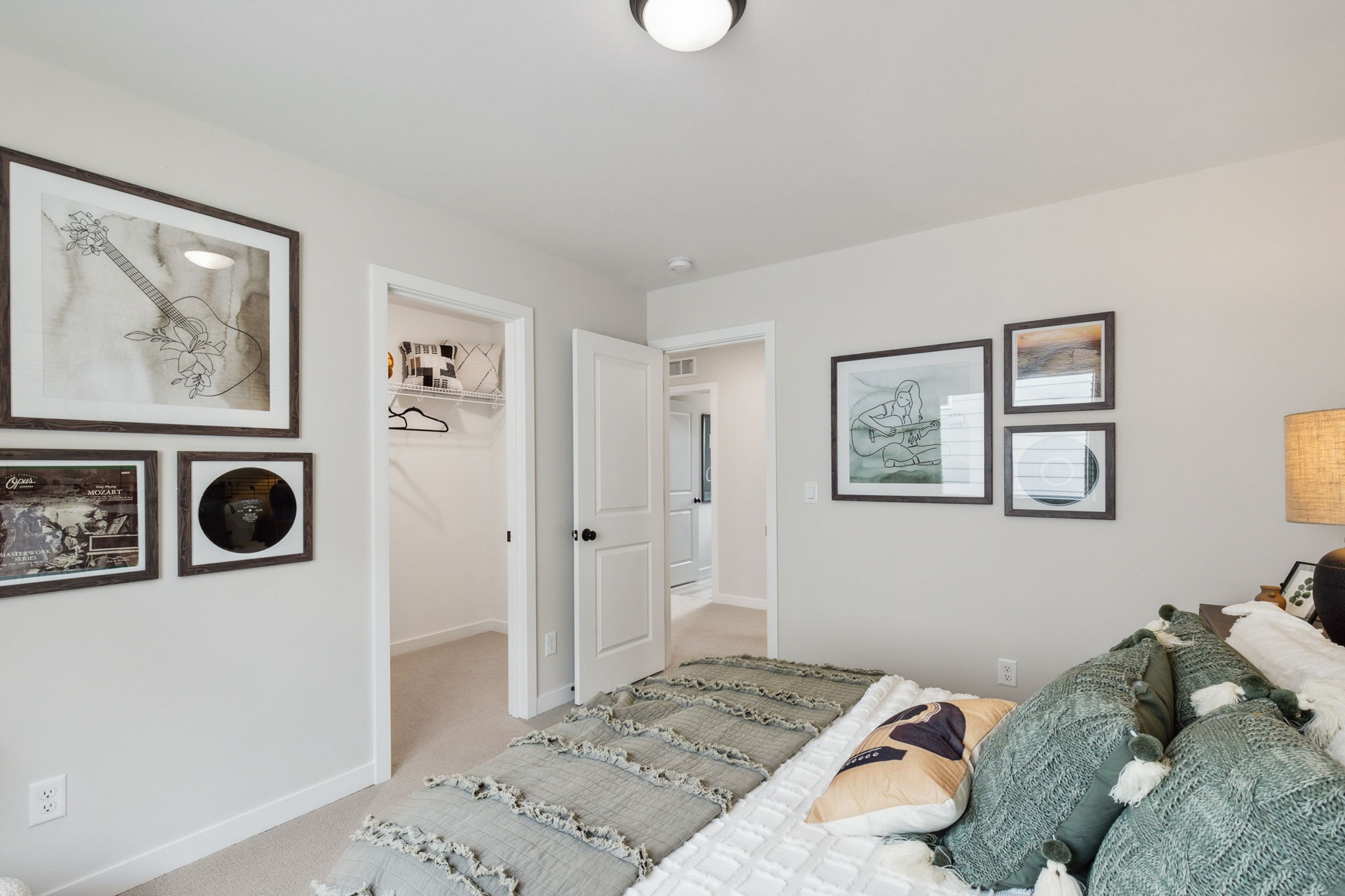 A bedroom with a bed and a lamp.