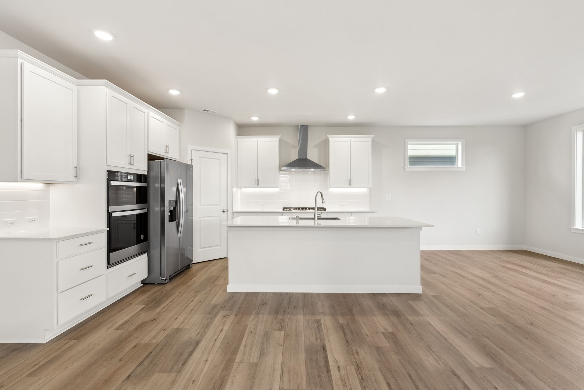 A kitchen with white cabinets.