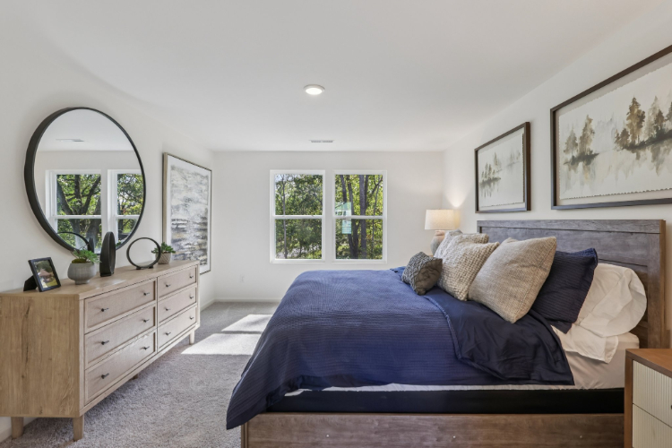 A bedroom with a bed and a mirror.