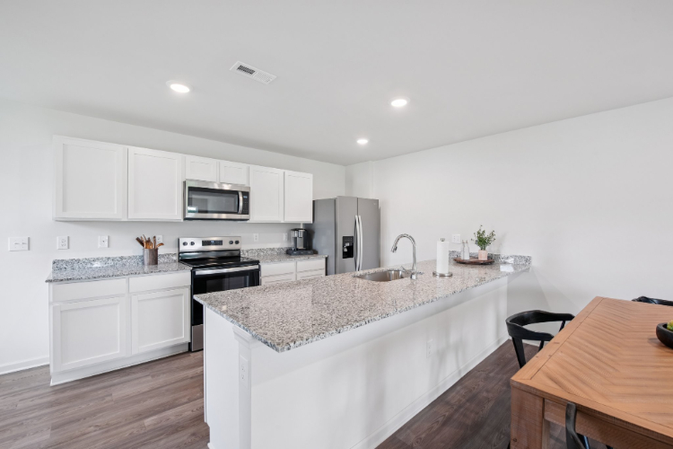 A kitchen with white cabinets.