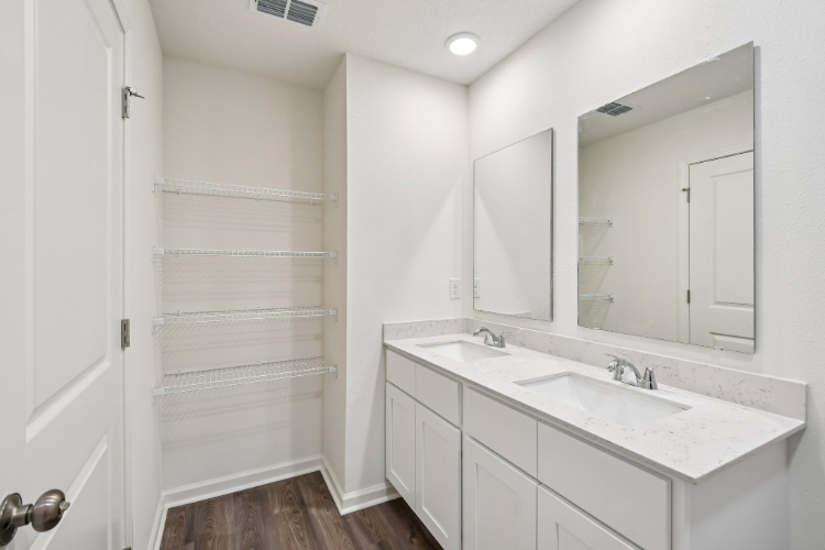 A bathroom with white cabinets.