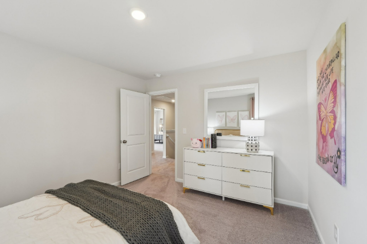 A bedroom with a bed and a lamp.