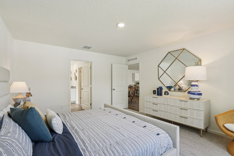 A bedroom with a bed and a mirror.